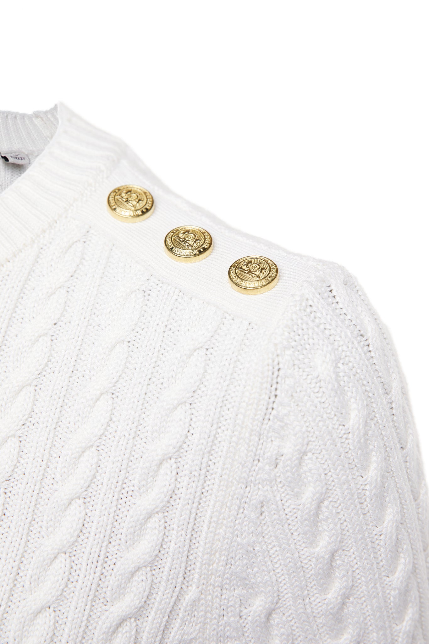 gold button detail on shoulders of womens cable knit jumper in white with ribbed crew neck cuffs and hem