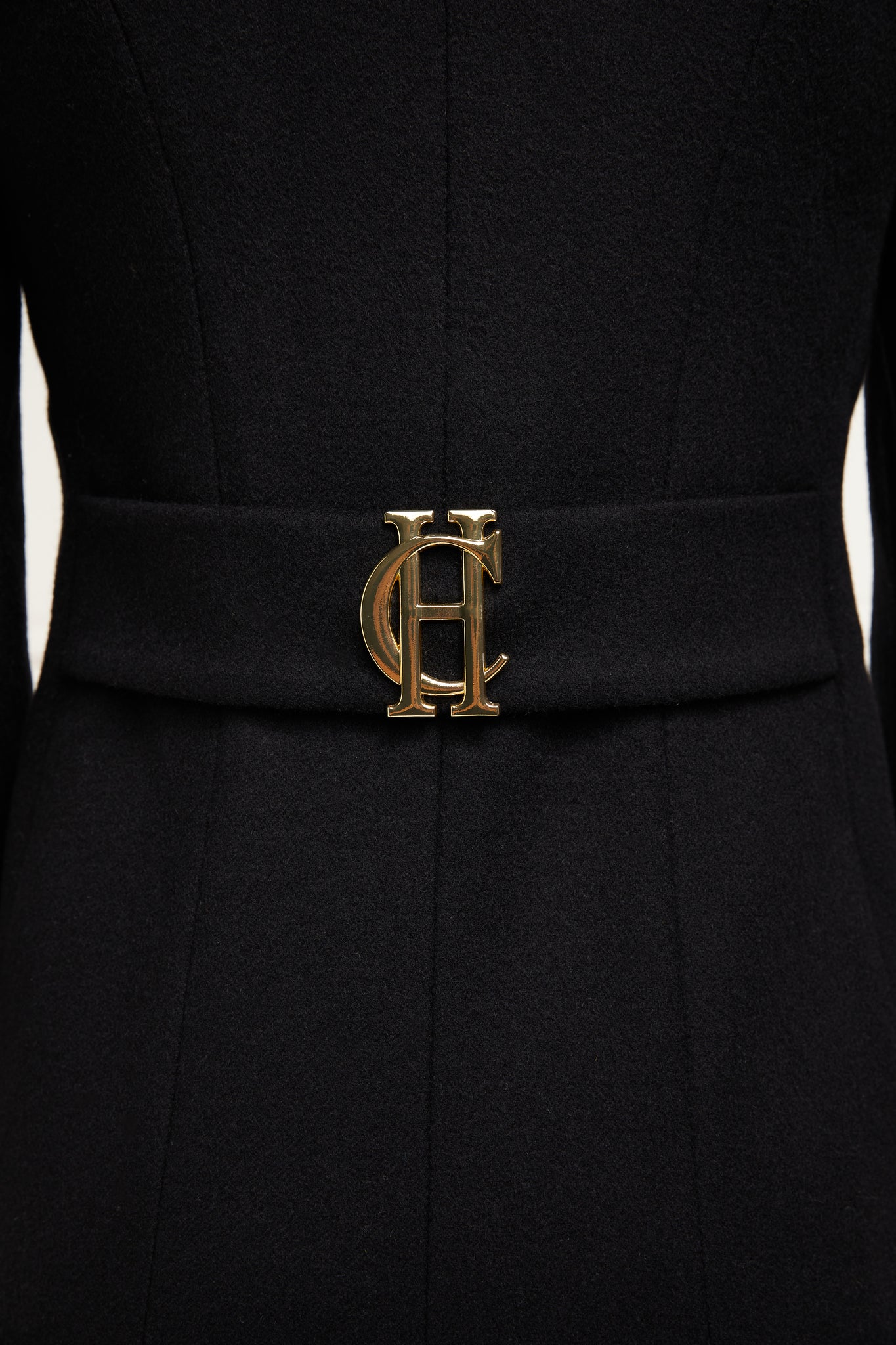 back with gold HC detail on black single breasted full length wool coat