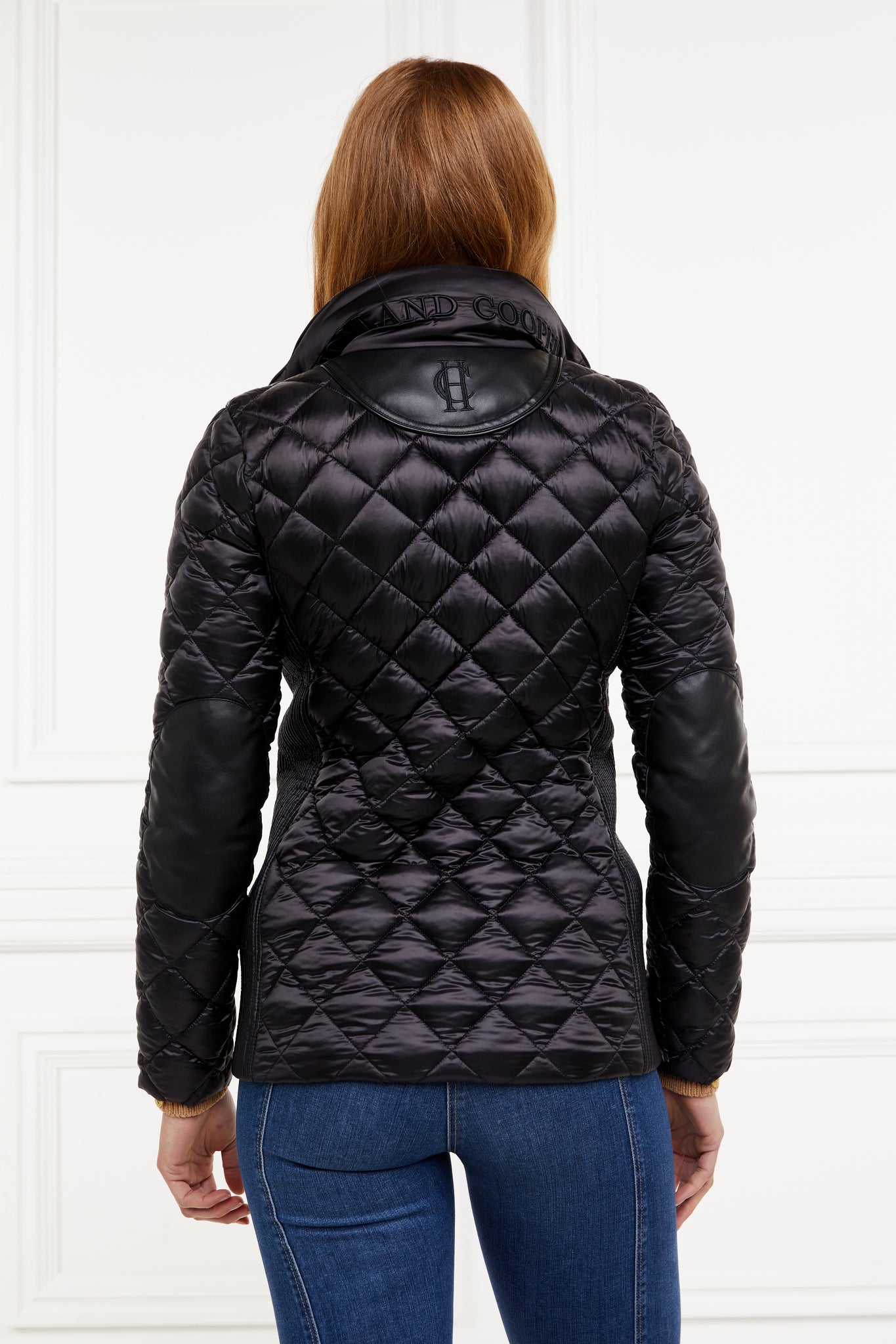  back of womens diamond quilted black jacket with contrast black leather elbow and shoulder pads large front pockets and shirred side panels