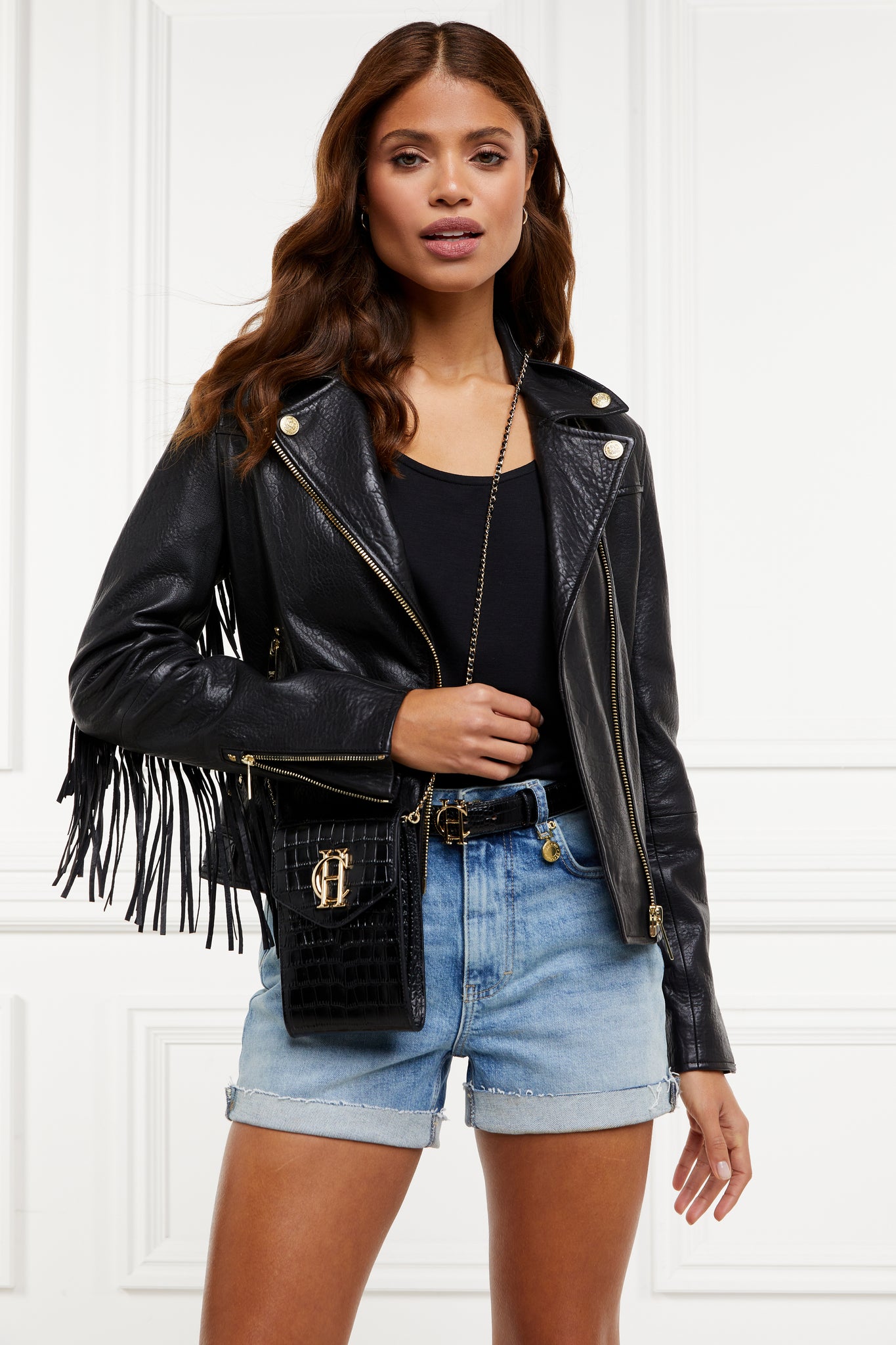 womens leather biker jacket in black with fringing along the back and sleeves detailed with golf zips and small shield badge on arm