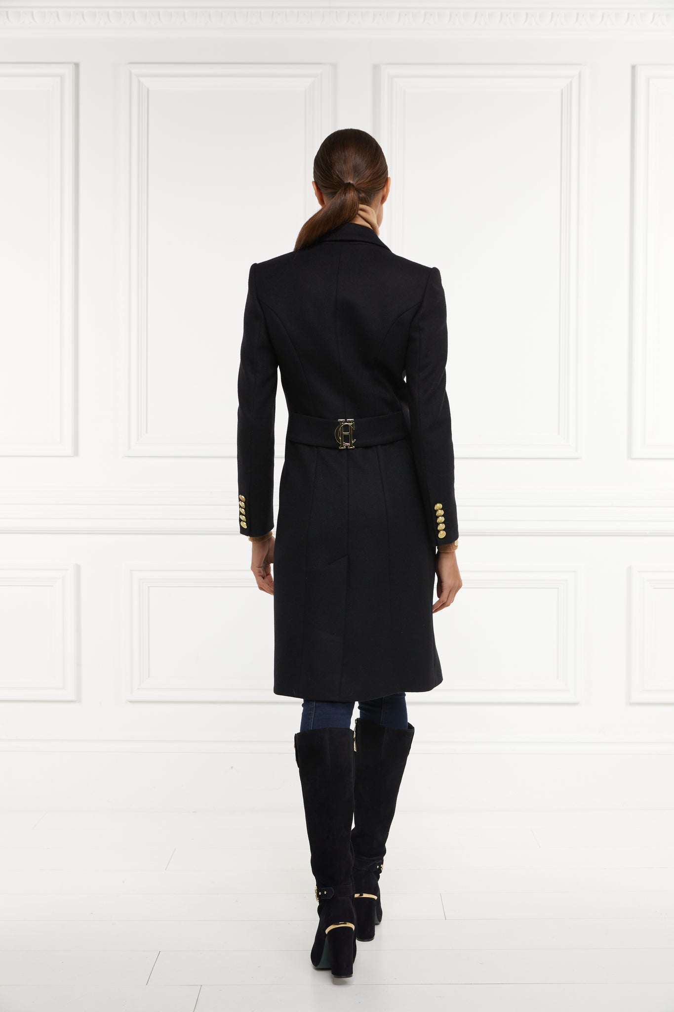 back of womens black wool knee length single breasted coat detailed with gold hardware