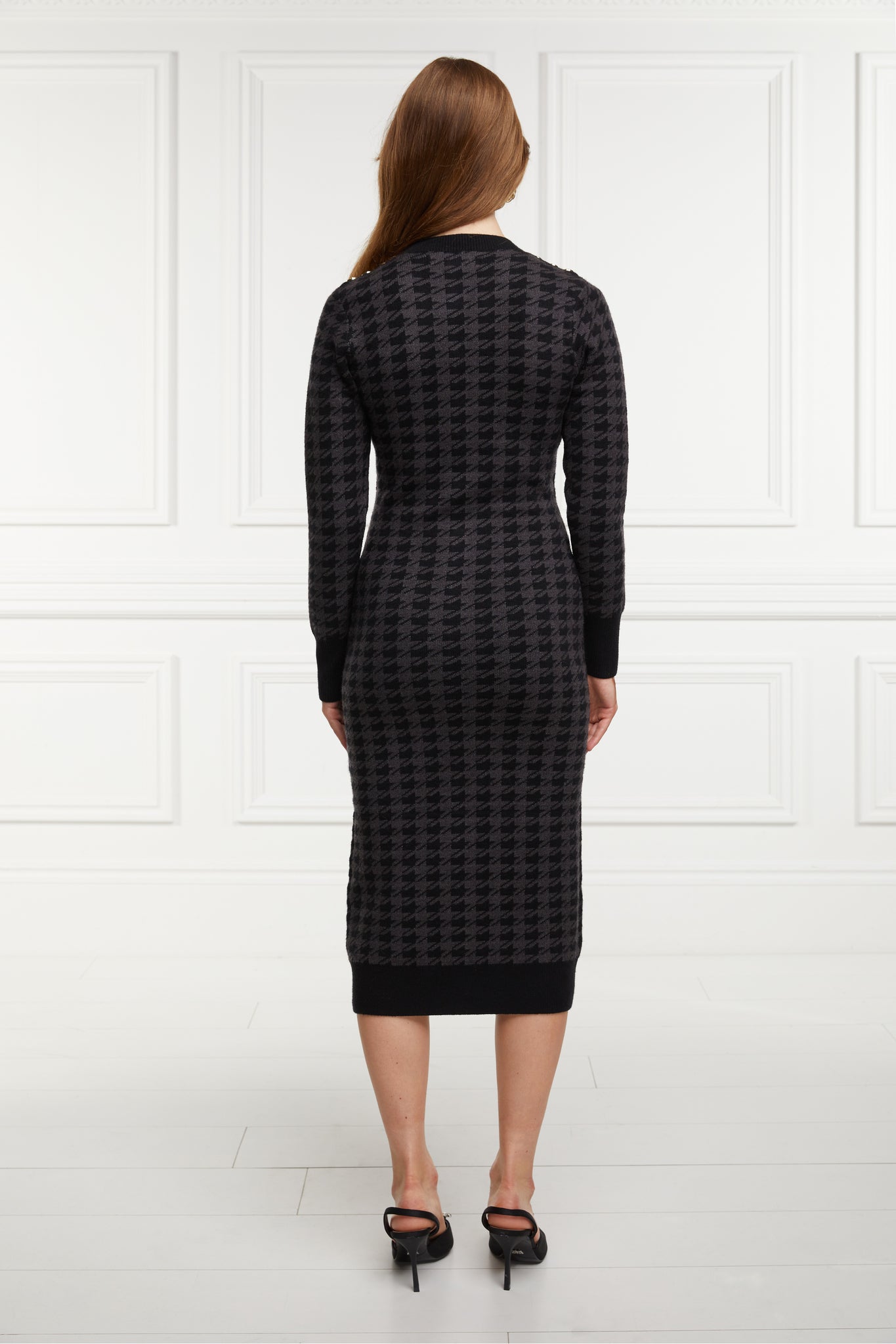 back of womens slim fit crew neck long sleeve knitted midi dress in grey and black houndstooth with gold button detail on contrast black panel down the centre front and two black contrast welt pockets on chest and two on the hips with gold buttons on the centre of each and contrasting black ribbed hem neckline and cuffs