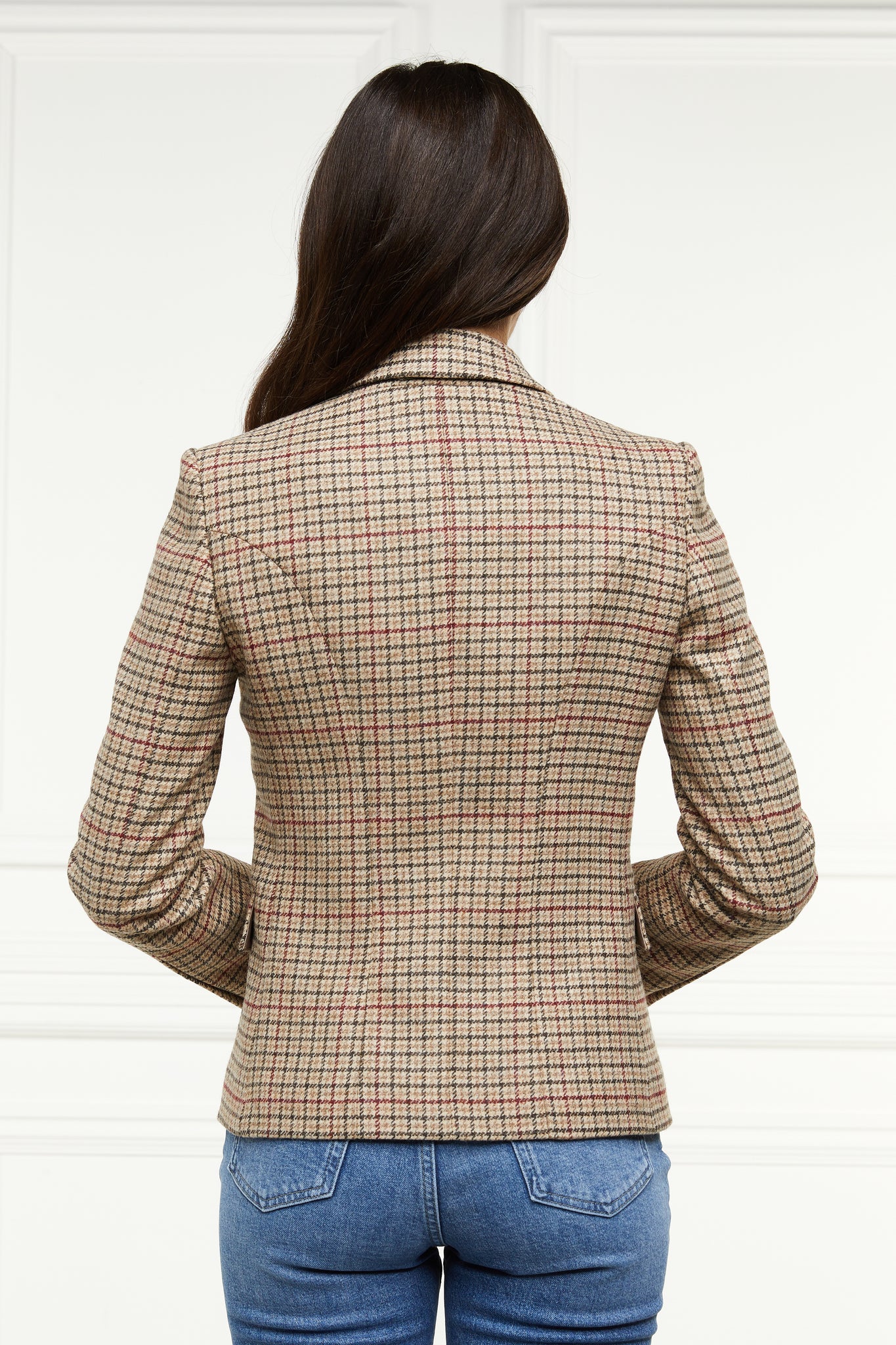 back of British made double breasted blazer that fastens with a single button hole to create a more form fitting silhouette with two pockets and horn button detailing this blazer is made from camel coloured charlton tweed