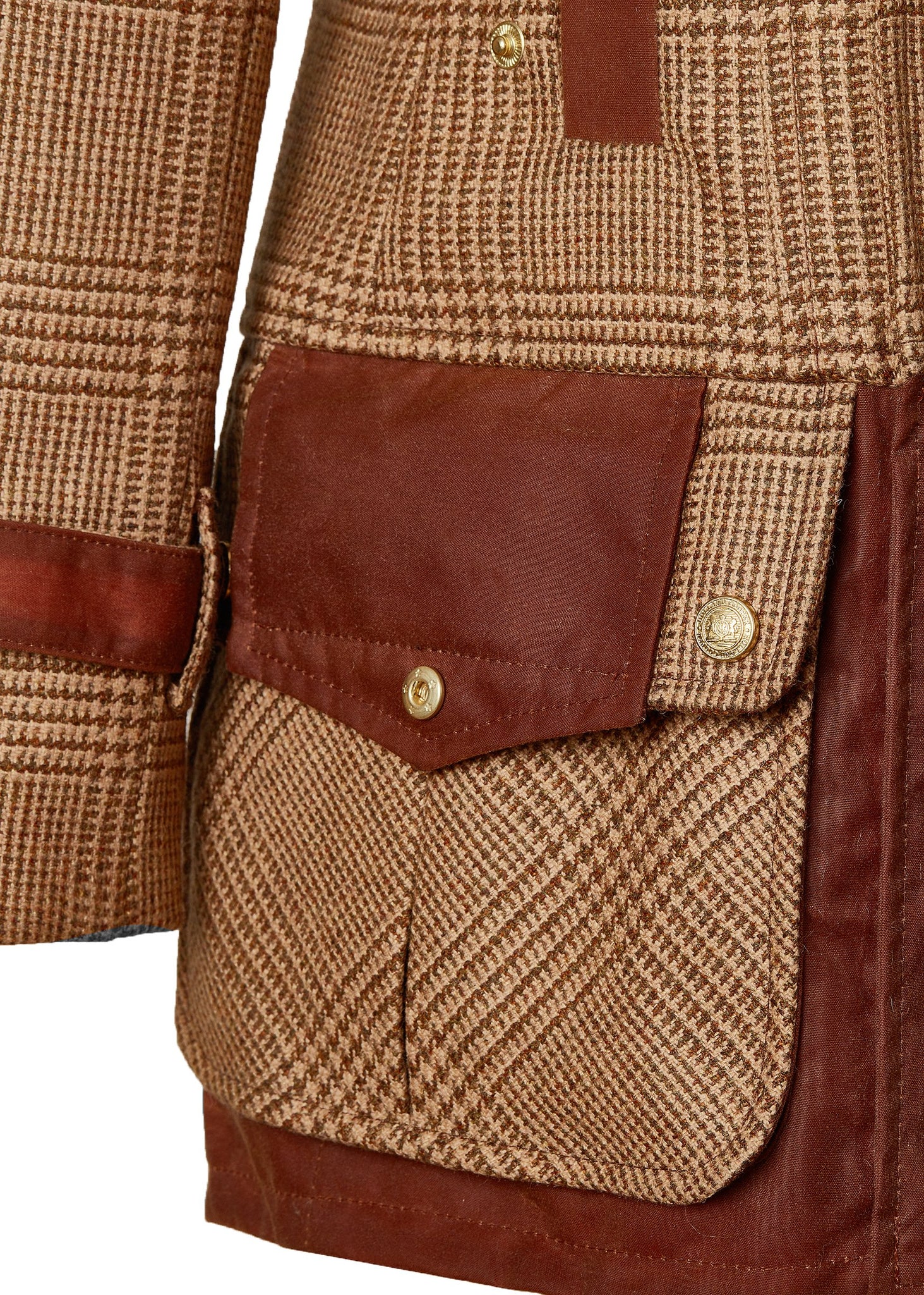pocket detail on hip of womens fitted field jacket in tawny and brown check tweed trimmed with contrast tan wax fabric on shoulder across back and on the hip with faux fur trim around the neck finished with horn button fastenings an buckles on the collar cuffs and hip
