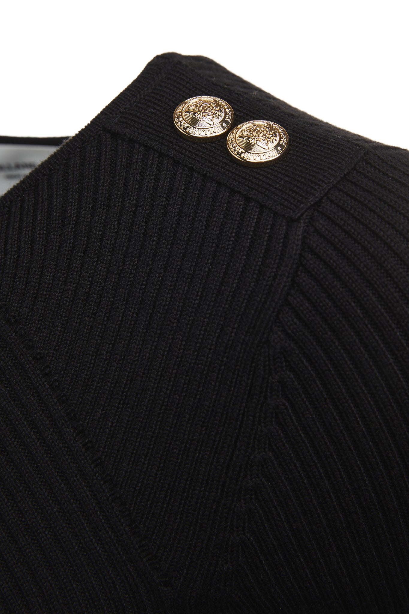 gold button detail across shoulders of a form fitting lightweight ribbed knit black jumper with a boat neckline and bell sleeves