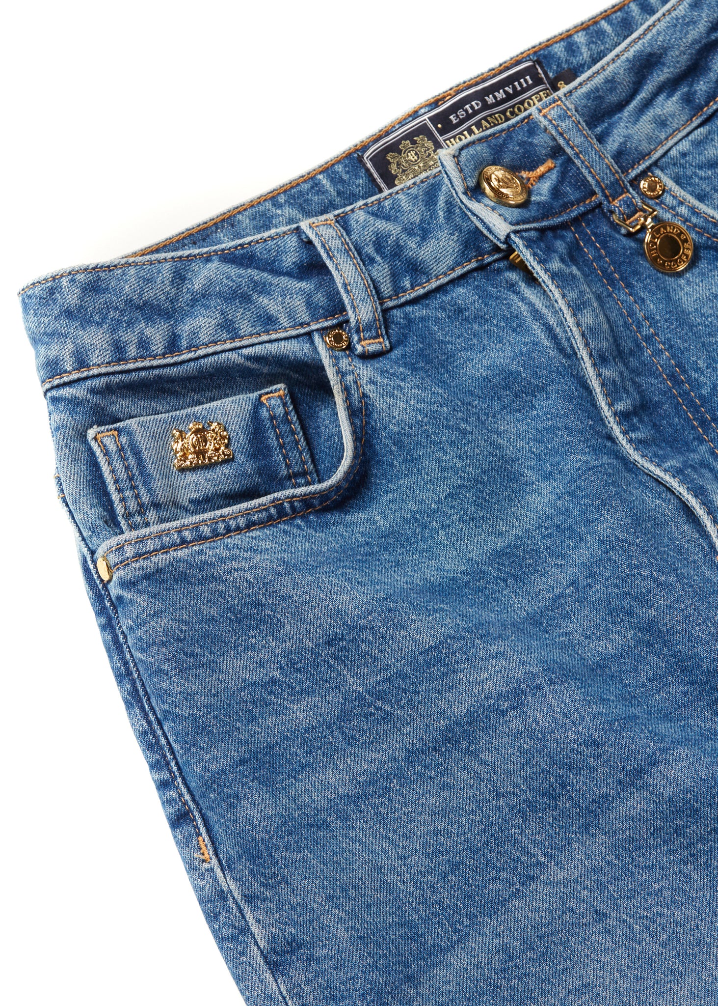 front pocket detail on womens high rise blue denim slim fit jean with raw hem and two open pockets on the front and back with gold stirrup charm to the belt loop