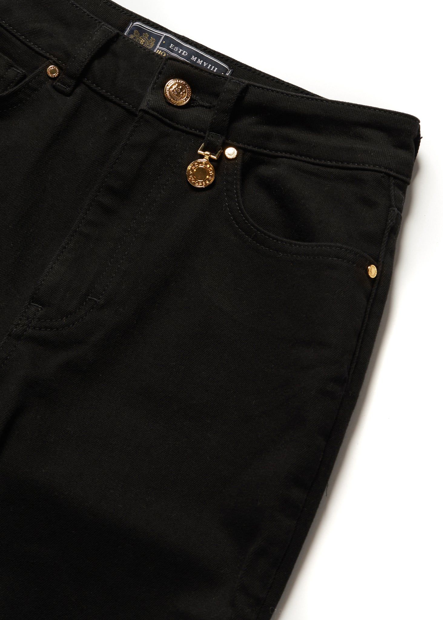 front pocket detail on womens high rise black denim slim fit jean with raw hem and two open pockets on the front and back with gold stirrup charm to the belt loop