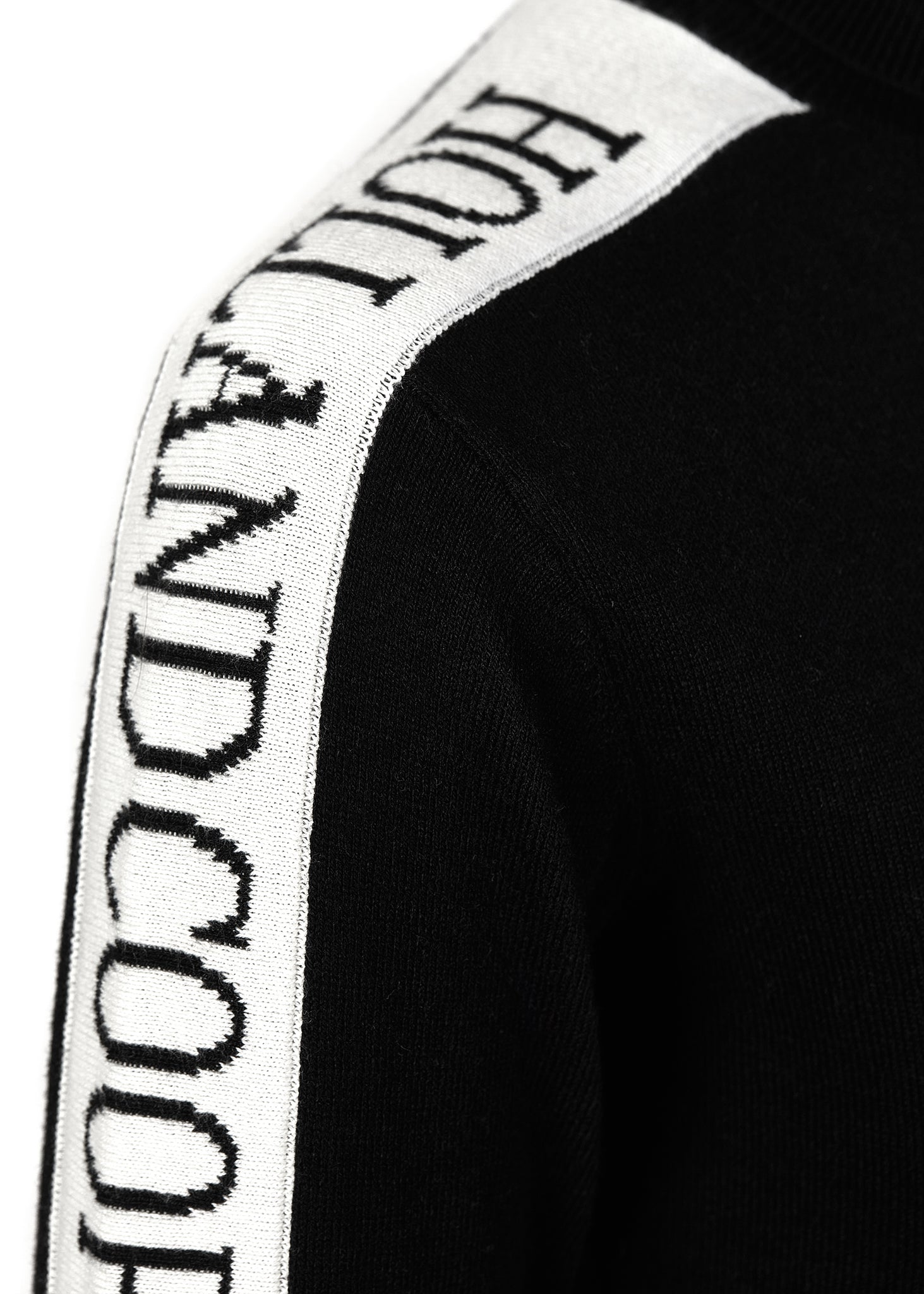 detail of white monogram intarsia knit panels down tops of arms on thermal fitted roll neck knit in black 
