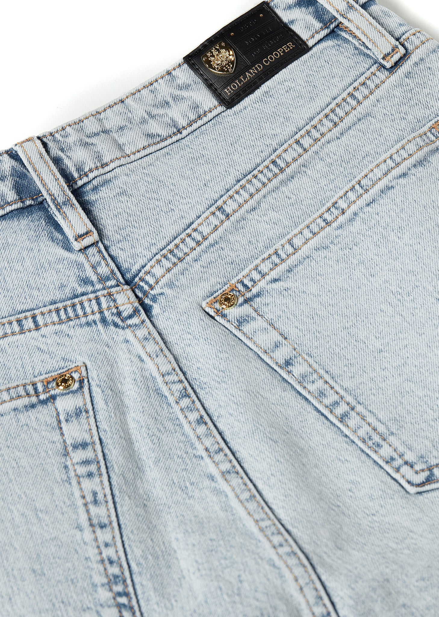 back pocket detail on womens high rise light blue denim slim fit jean with raw hem and two open pockets on the front and back with gold stirrup charm to the belt loop