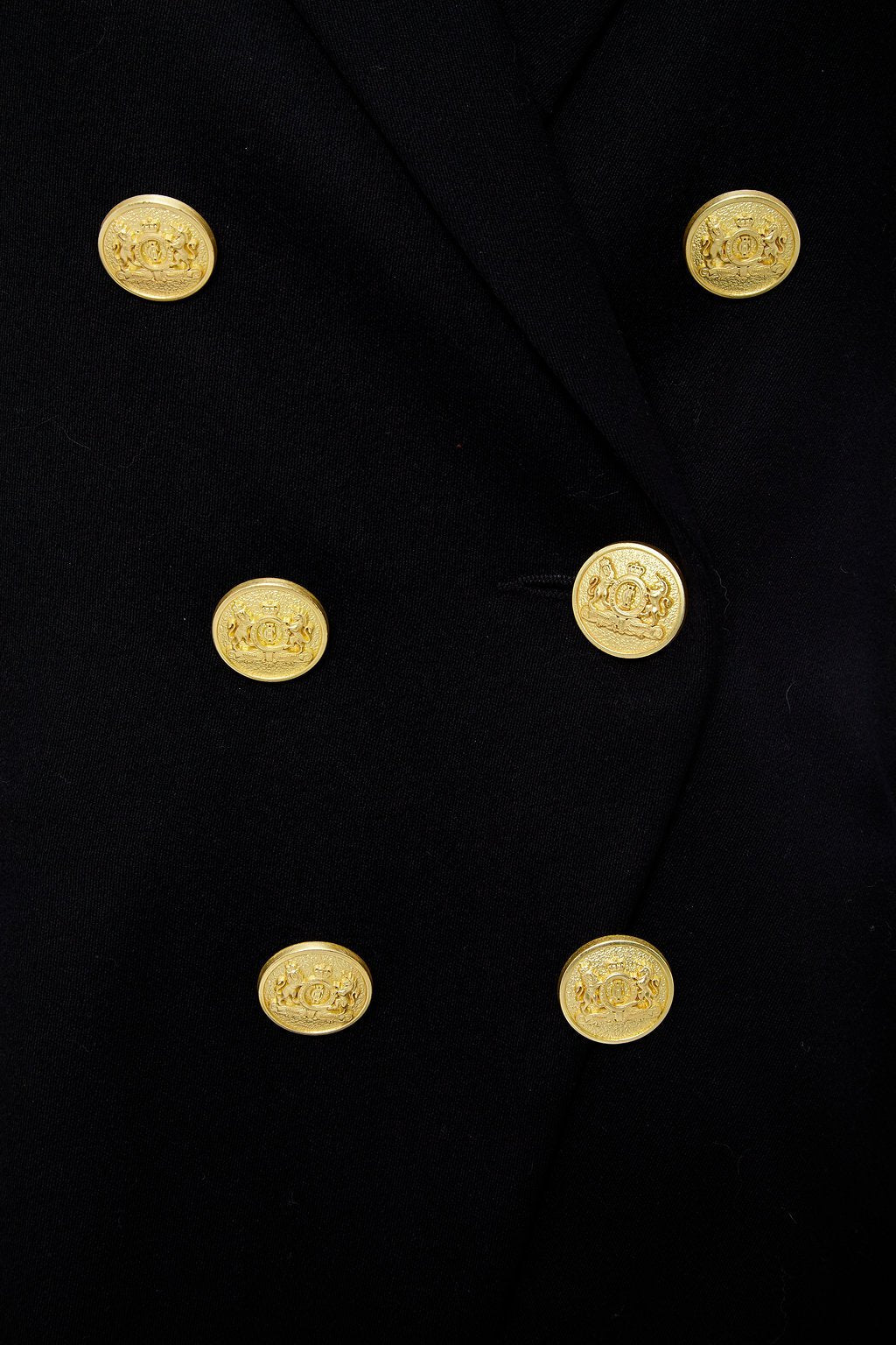 gold button detail on British made double breasted blazer that fastens with a single button hole to create a more form fitting silhouette with two pockets and gold button detailing this blazer is made from black barathea