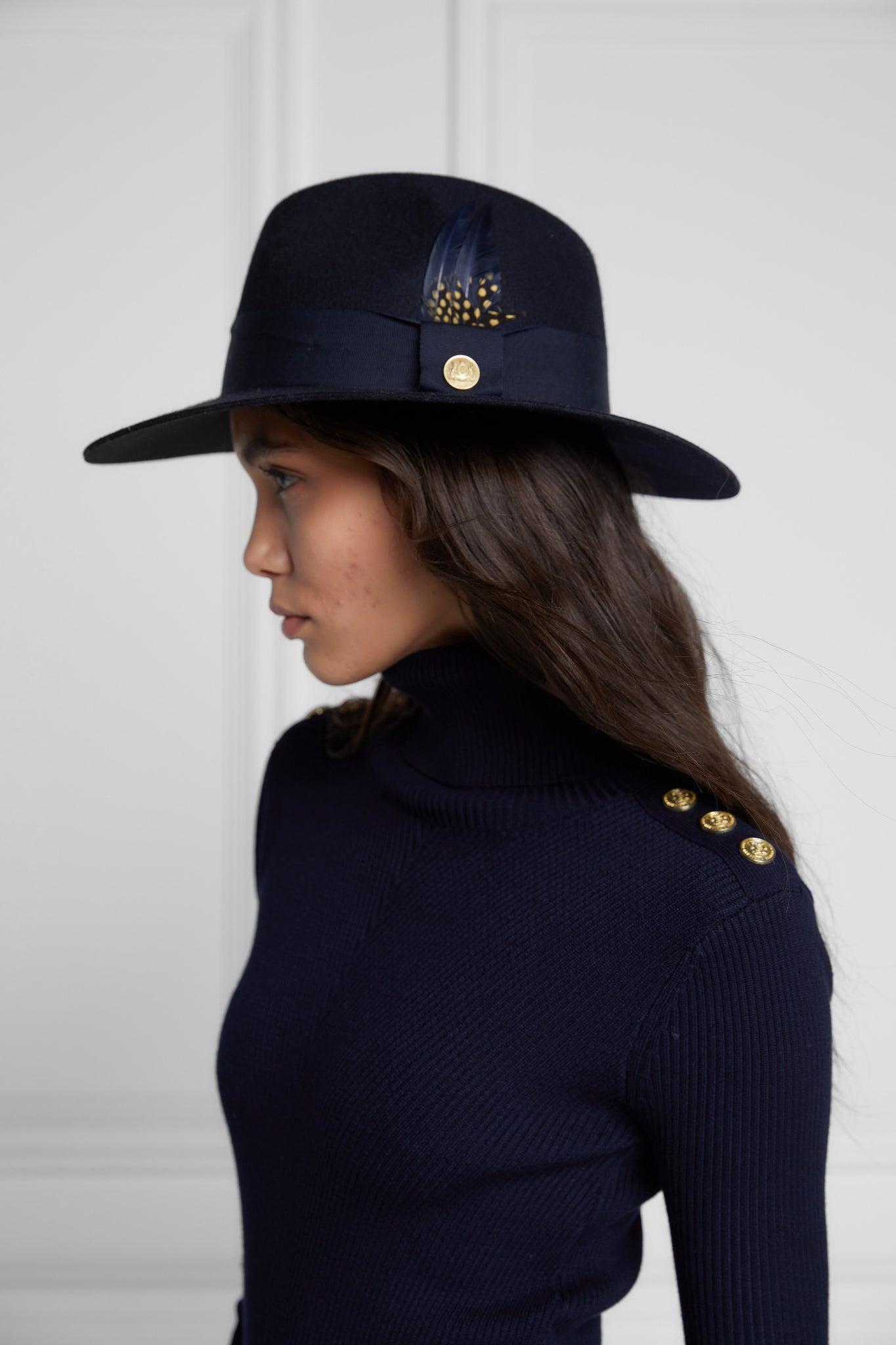 womens body-contouring navy knitted midi dress with ribbed roll neck and cuffs and gold buttons on shoulders and cuffs with navy fedora