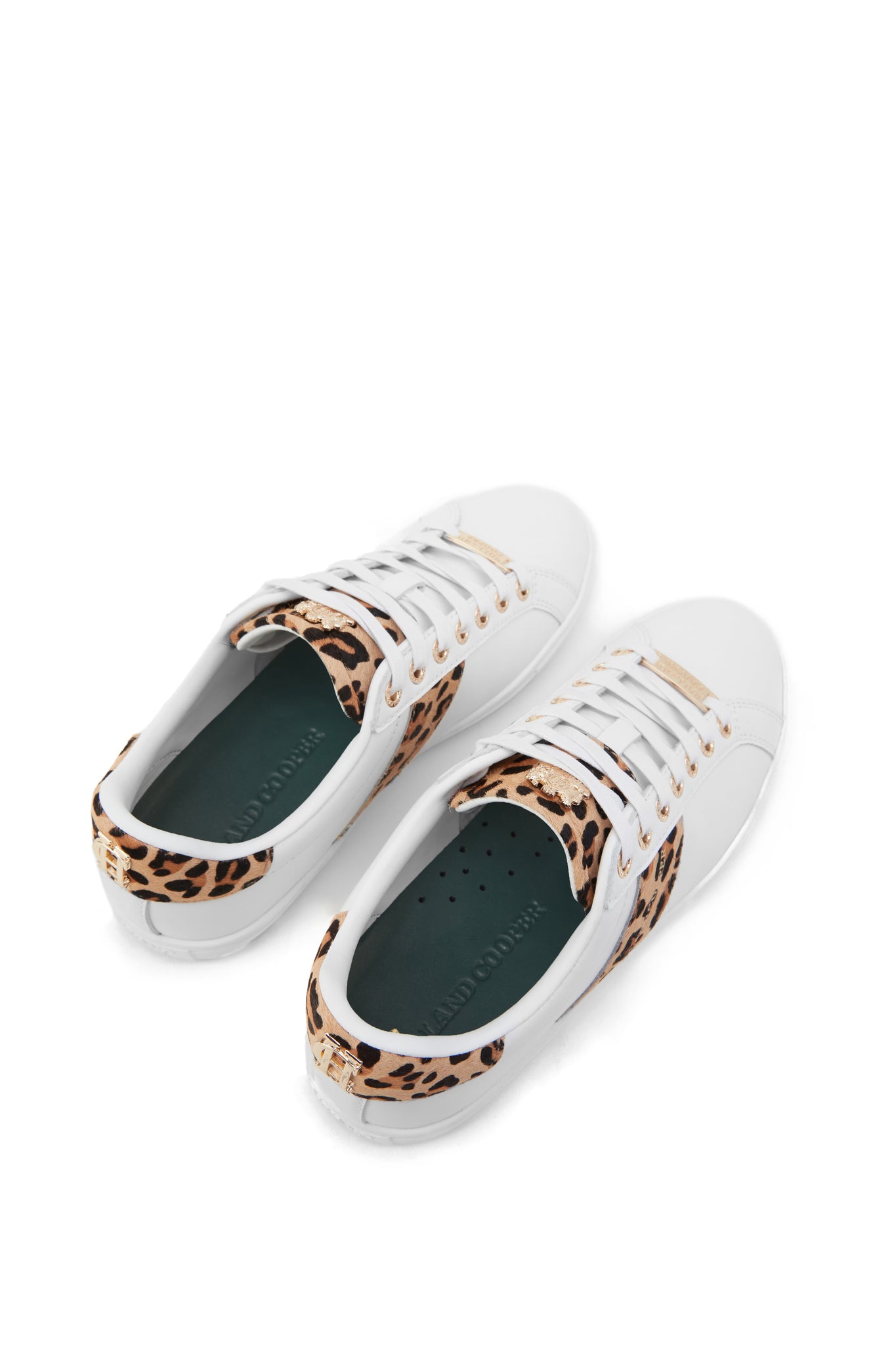 Birds eye view of white leather trainers with white laces detailed with a diagonal stripe of leopard print on the side with gold foil branding and a leopard print heel and tongue with gold hardware