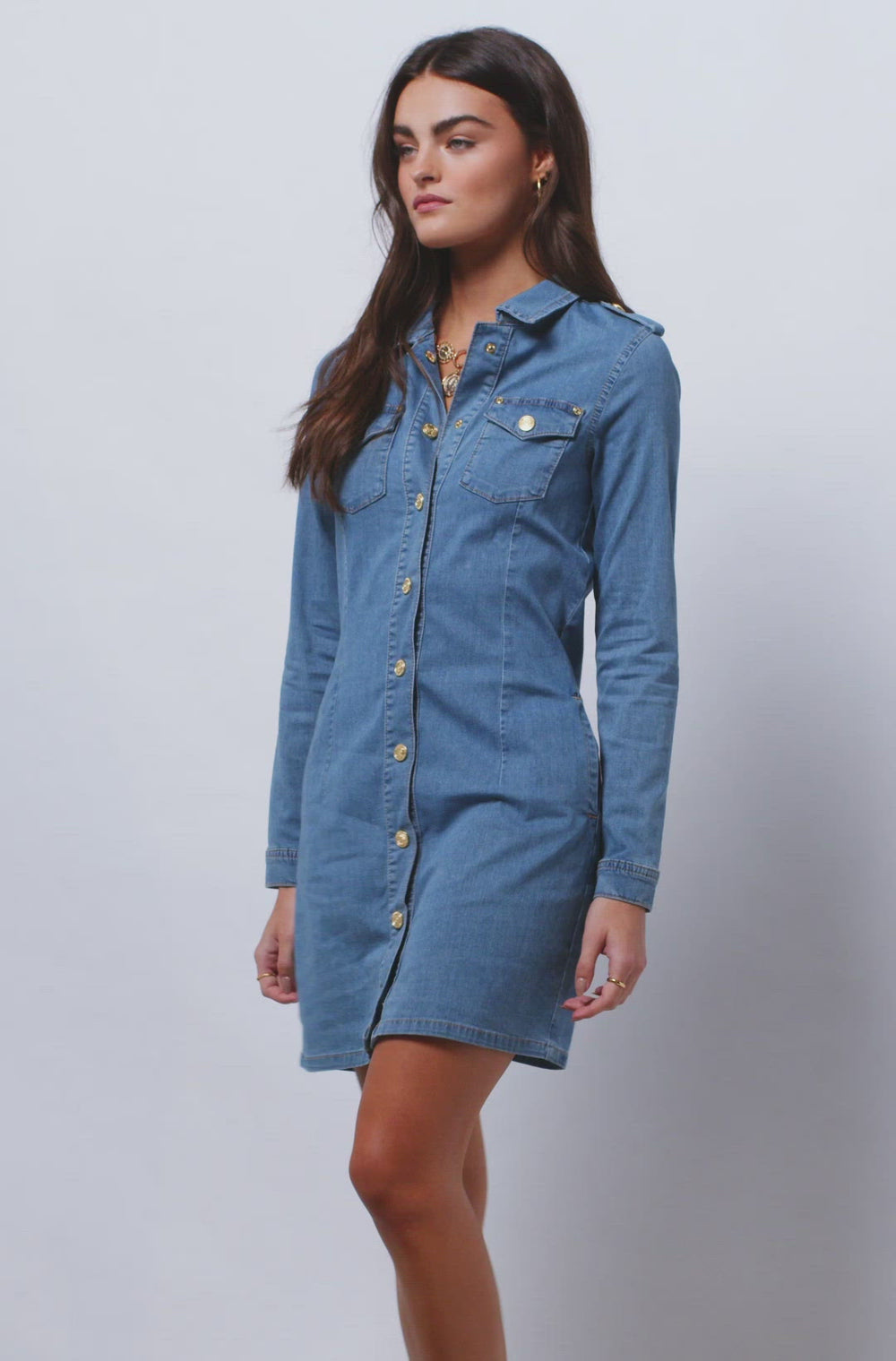 video of womens long sleeve blue denim shirt mini dress with gold buttons down the front