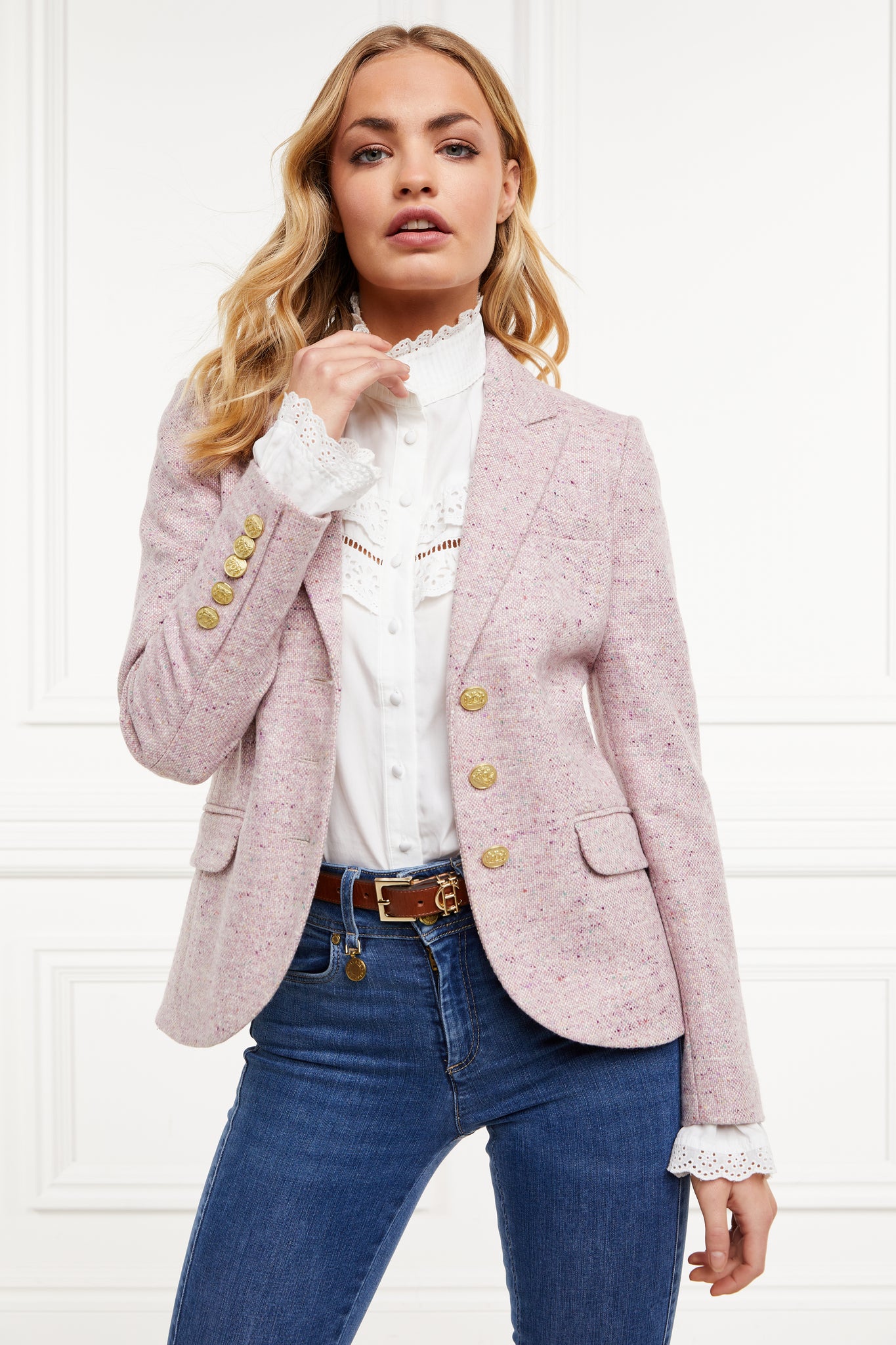 a classic single breasted blazer in pale pink that is tailored with a a classic cut and fitted silhouette with welt pockets and gold button detail on the front and sleeves worn with white shirt and classic denim skinny jeans 