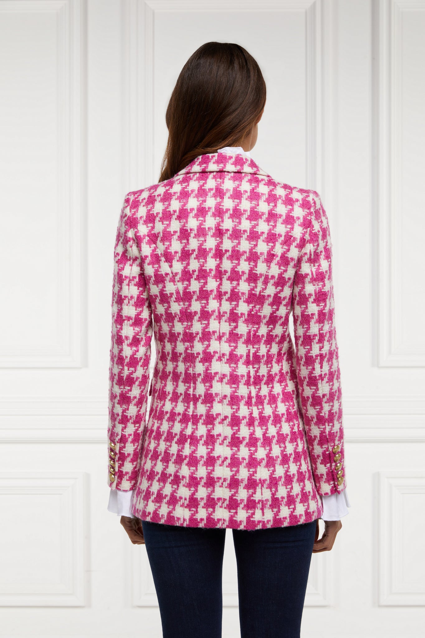 back of double breasted wool blazer in hot pink large scale houndstooth with two hip pockets and gold button detials down front and on cuffs and handmade in the uk