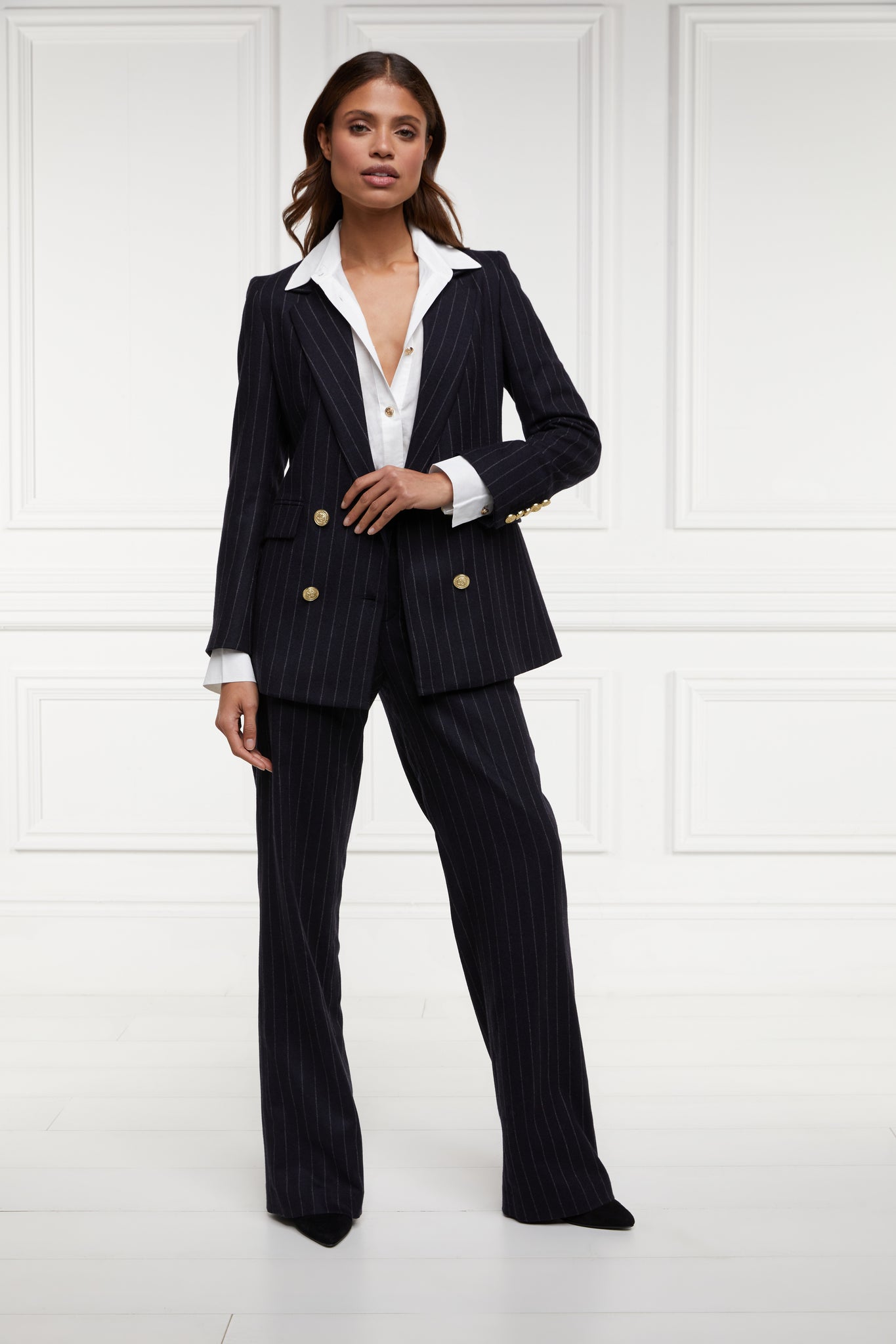 double breasted wool blazer in navy and cream chalk pinstripe with two hip pockets and gold button detials down front and on cuffs and handmade in the uk worn with classic white shirt and tailored trousers in matching pinstripe