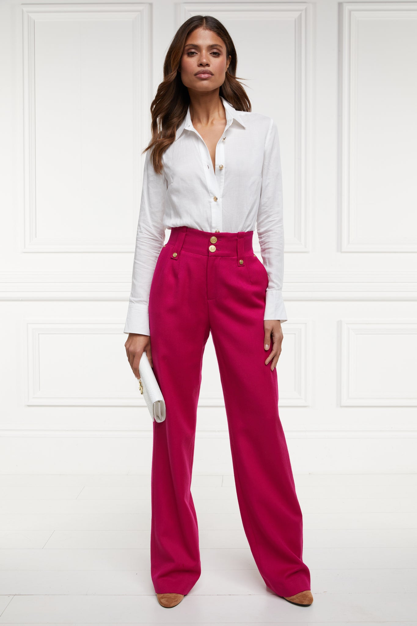 Women's hot pink wool high waisted straight trousers with classic white shirt and white croc clutch bag