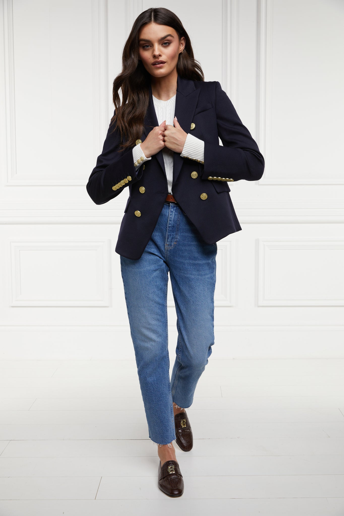 womens cable knit jumper in white with ribbed crew neck cuffs and hem worn with a double breasted blazer in navy