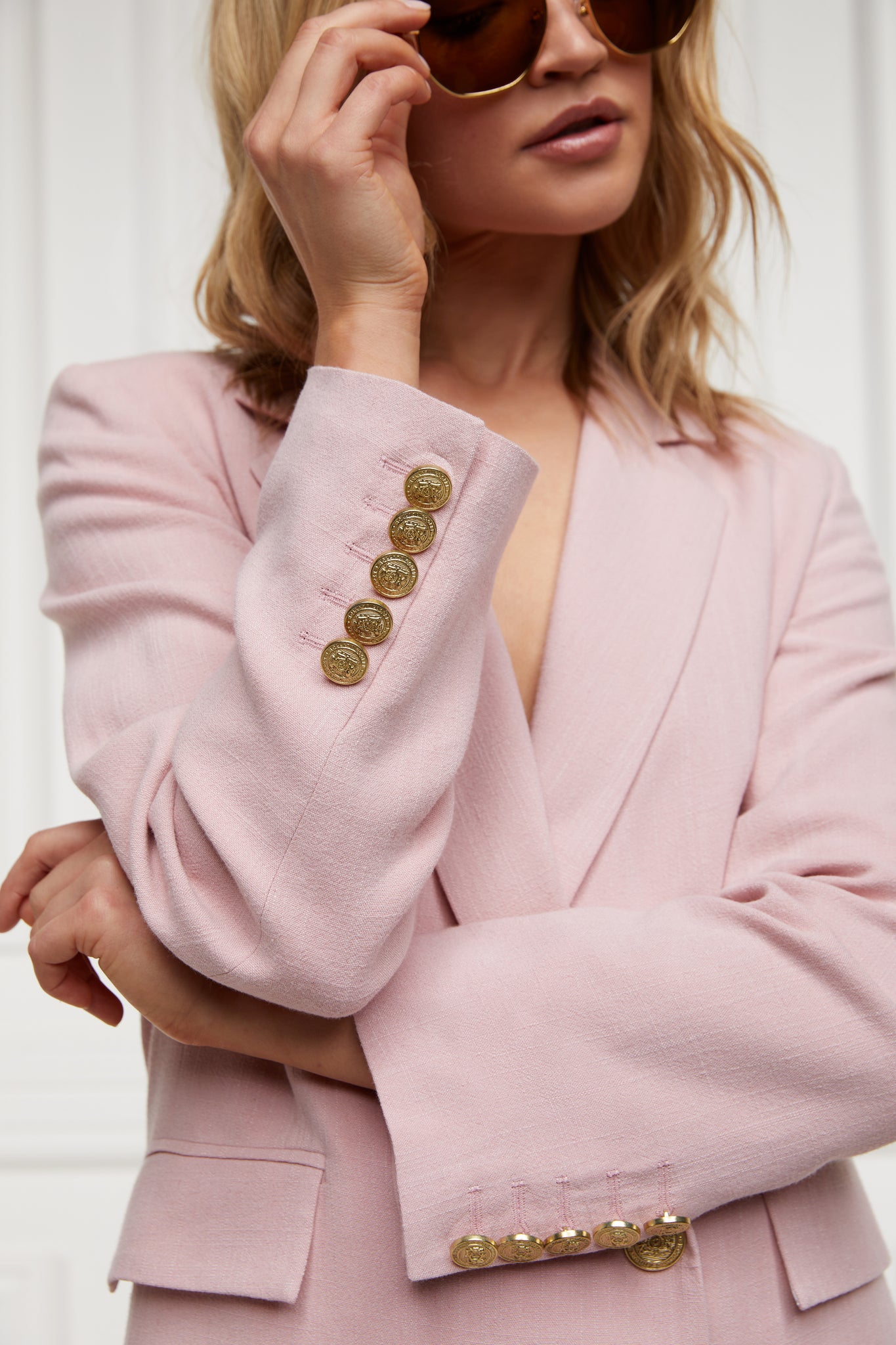 gold button detail on cuffs of double breasted linen blazer in pale pink with two hip pockets and gold button detials down front and on cuffs and handmade in the uk 