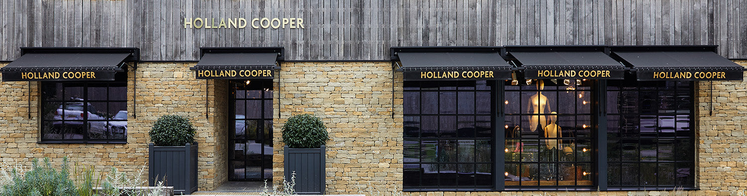 Holland Cooper Womens Boutique Store with gold lettering and cotswold yellow stone building with black glass door and windows