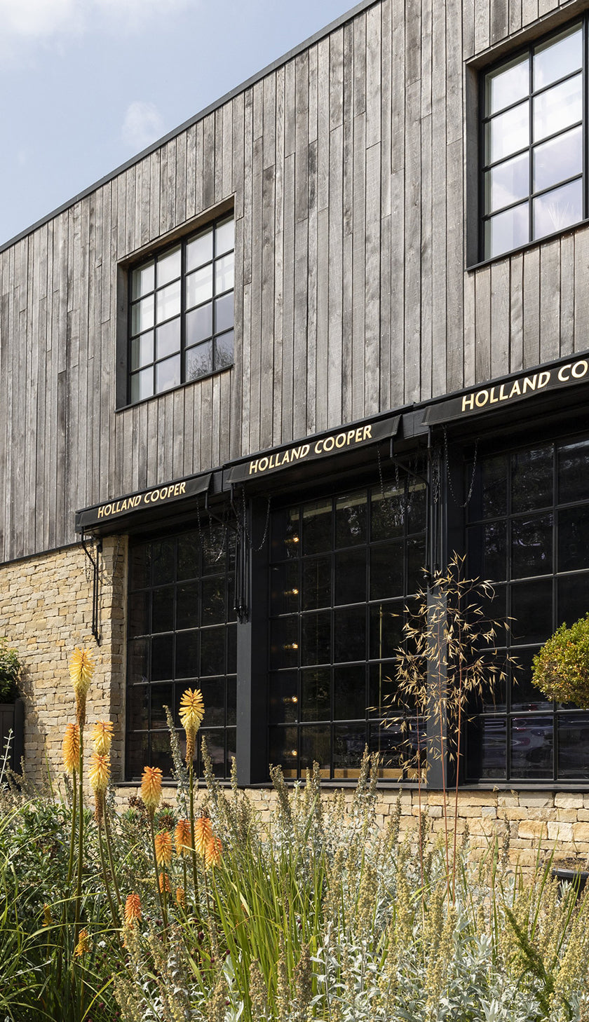 Holland Cooper Womens Boutique Store with gold lettering and cotswold yellow stone building with black glass windows