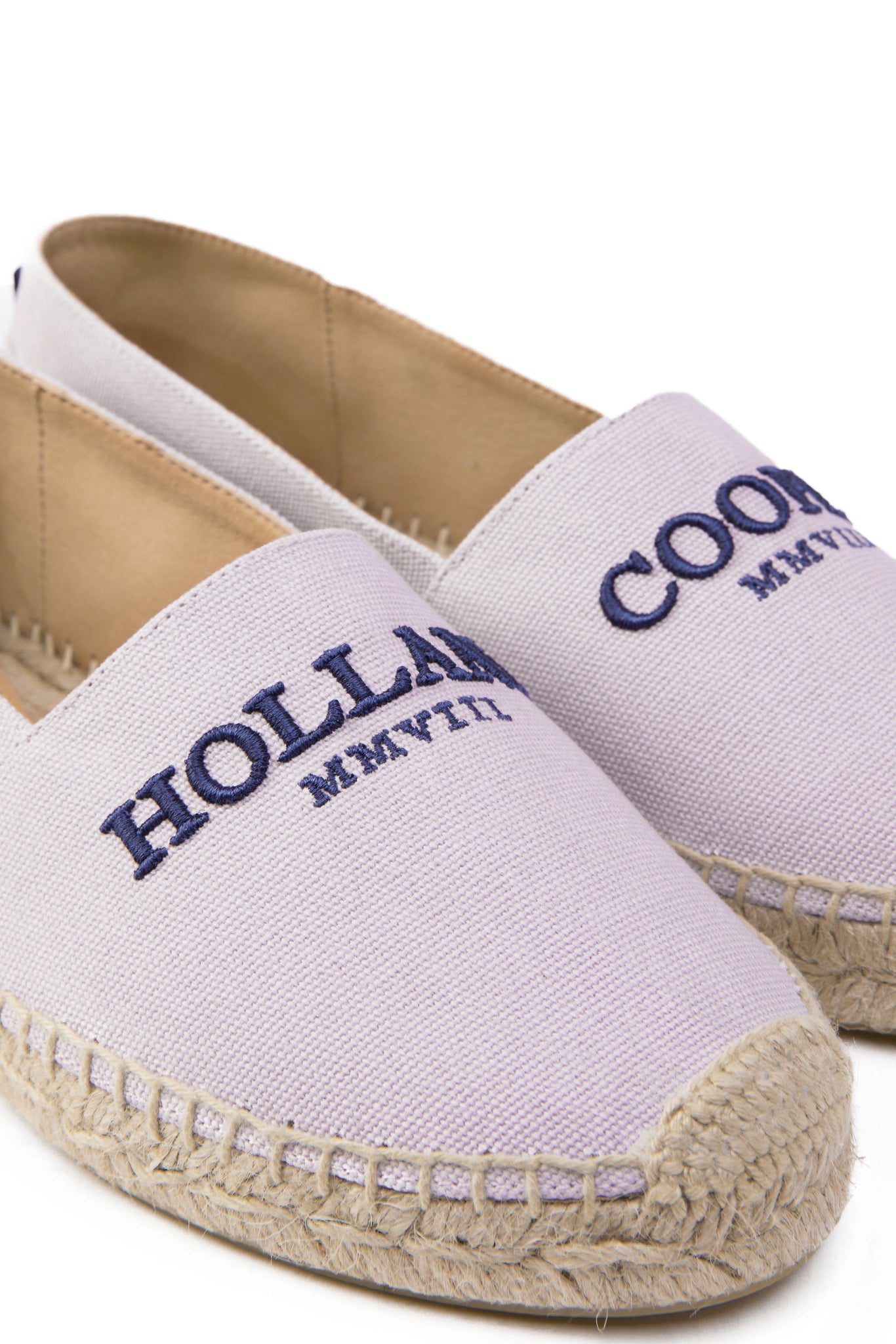 Close up of classic style light pink canvas espadrille with plaited jute sole and jute toe cap with navy embroidered branding on top