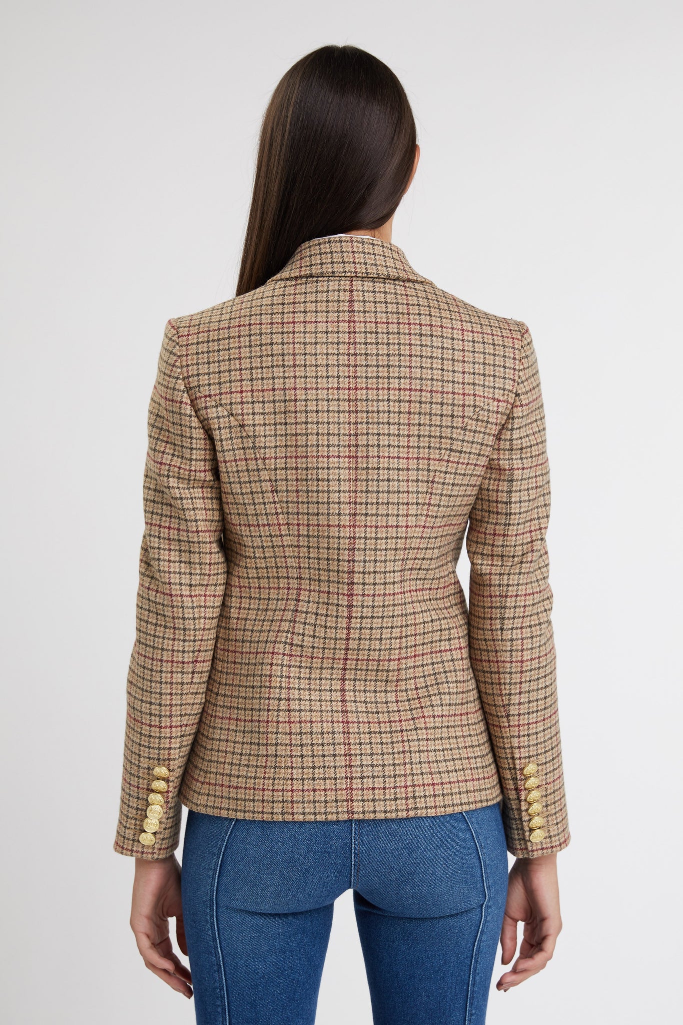 back of British made double breasted blazer that fastens with a single button hole to create a more form fitting silhouette with two pockets and gold button detailing this blazer is made from camel black and red check charlton tweed