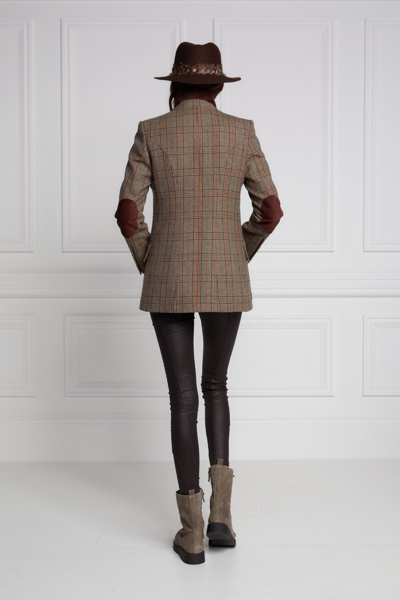 back of womens classic slim fit single breasted blazer in brown and orange tweed with lower patch pockets with concealed button flap contrast brown suede shoulder gun patch with elbow patches and horn button finish on cuffs and front 