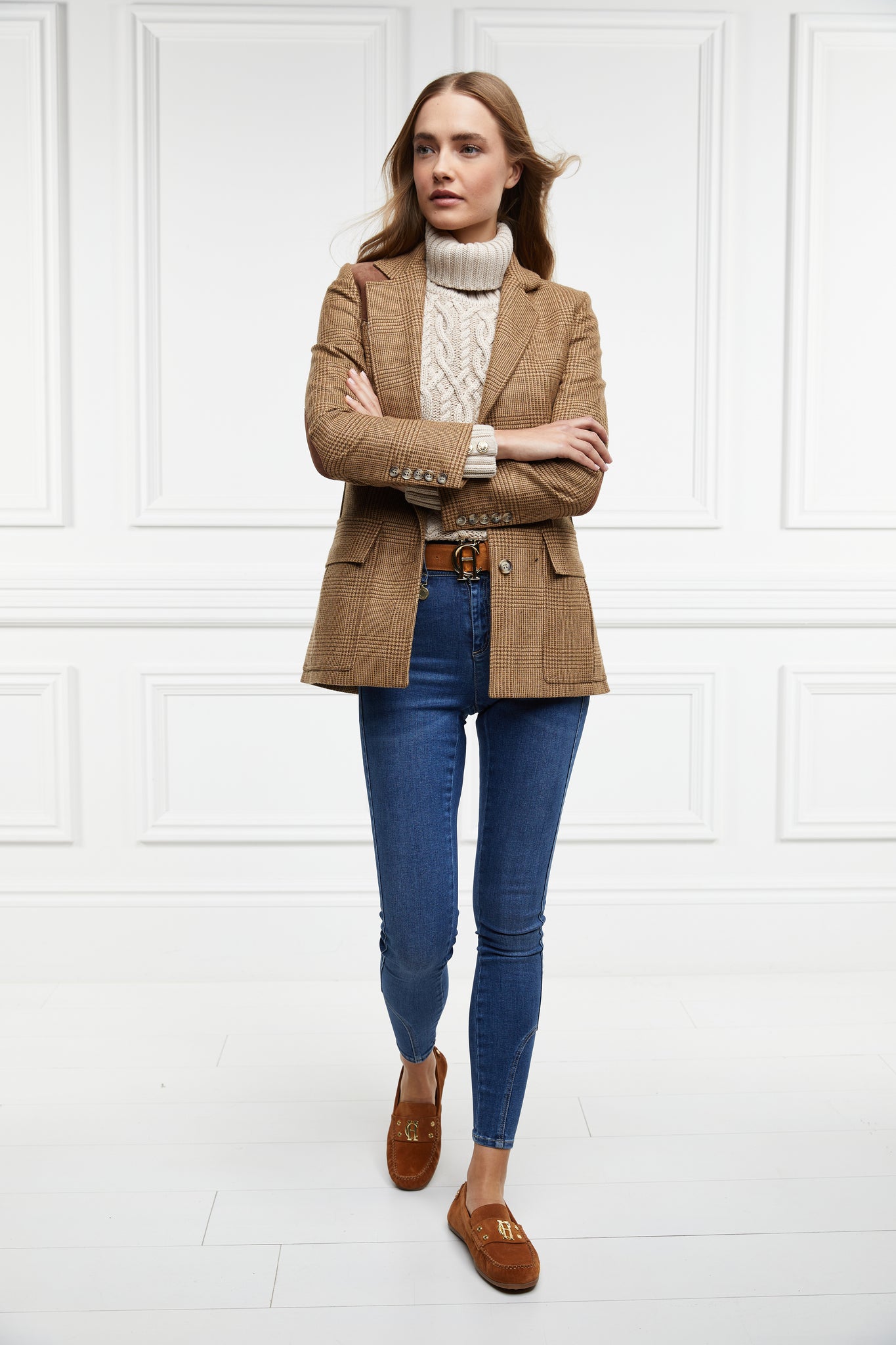 classic tan suede loafers with a leather sole and top stitching details and gold hardware paired with denim skinny jeans, cream cable knit jumper, tawny blazer and brown leather belt