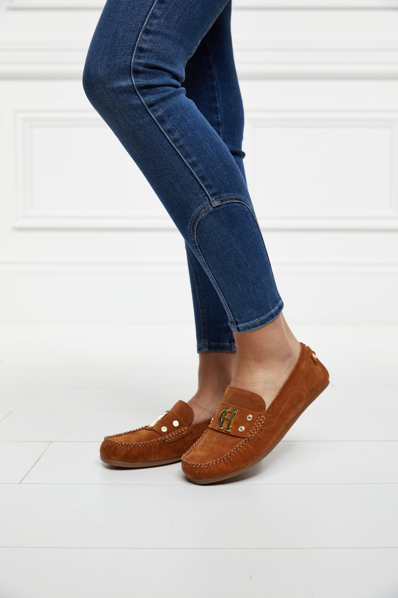 classic tan suede loafers with a leather sole and top stitching details and gold hardware paired with denim skinny jeans