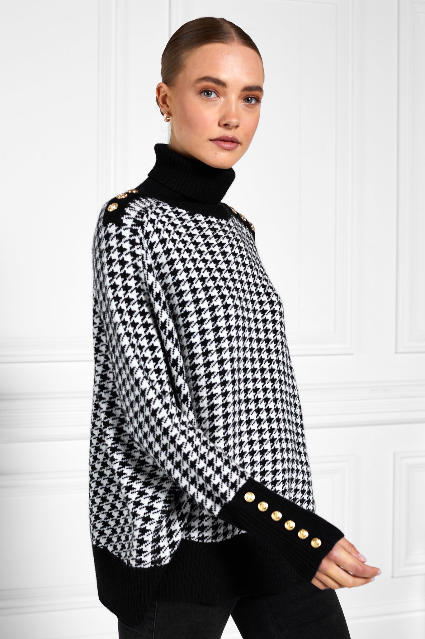 womens funnel neck batwing shaped cape in a white and black houndstooth knit with split side detail and contrast black neckline cuffs and hem