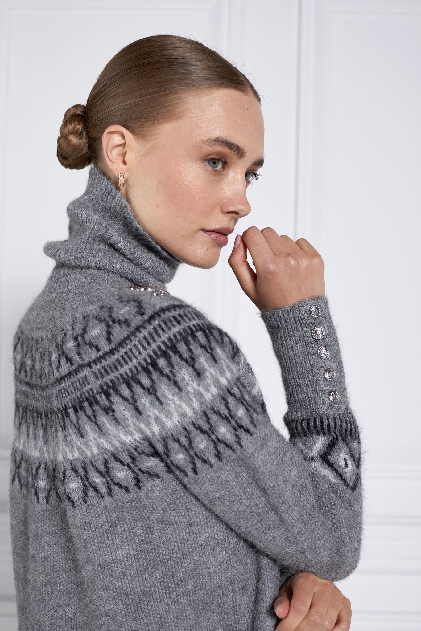 side of womens classic grey roll neck jumper with fairisle knit in black and white around the shoulders waistline and cuffs and a split ribbed hem