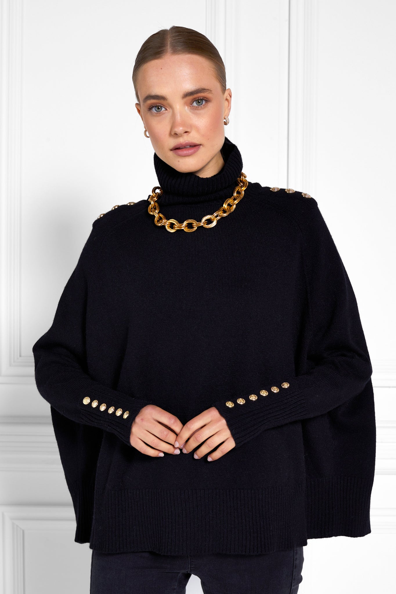 womens funnel neck batwing shaped cape in black knit with split side detail and ribbed neckline cuffs and hem