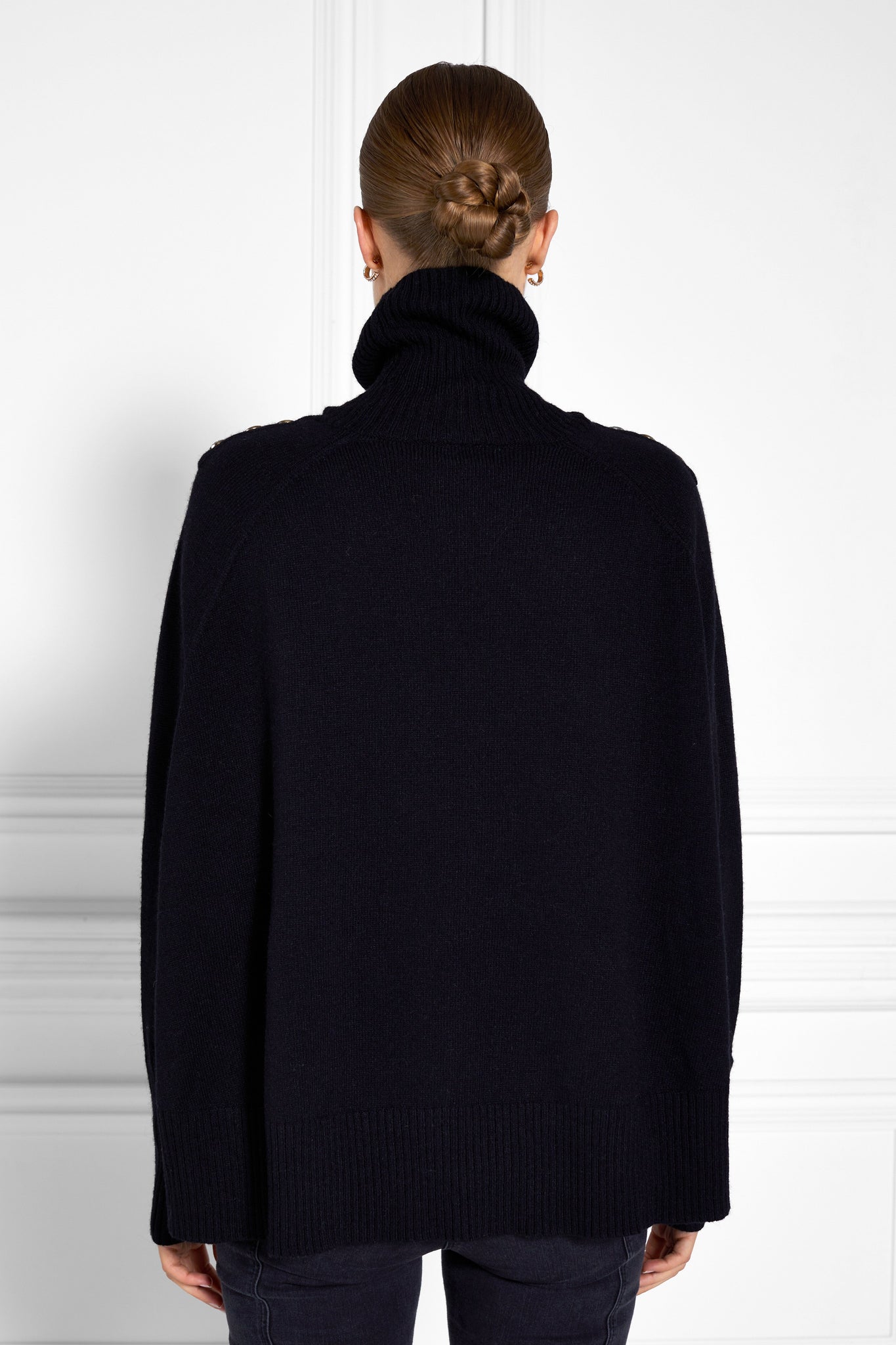 back of womens funnel neck batwing shaped cape in black knit with split side detail and ribbed neckline cuffs and hem