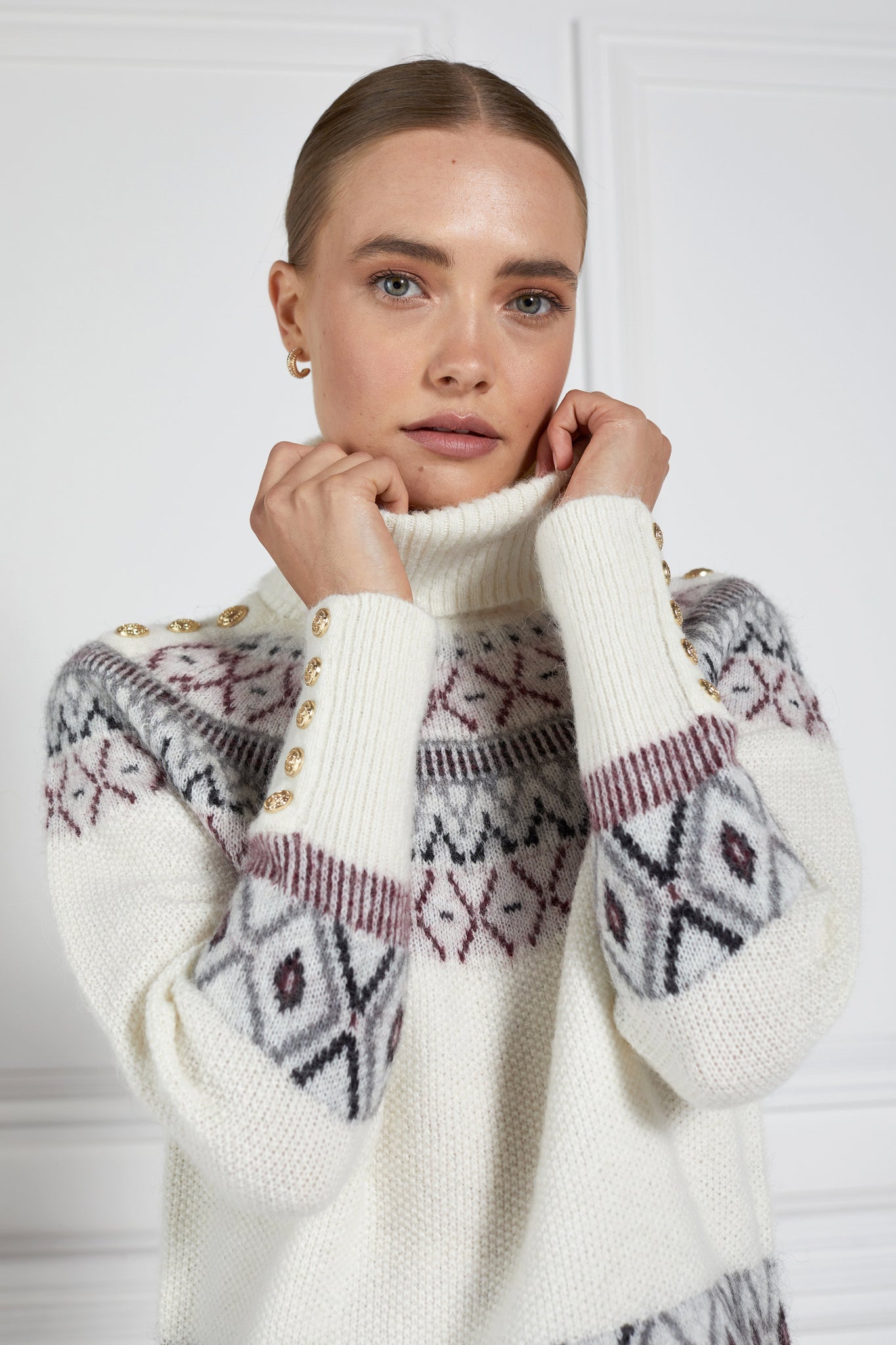  a classic cream roll neck jumper with fairisle knit in red and grey around the shoulders waistline and cuffs and a split ribbed hem 