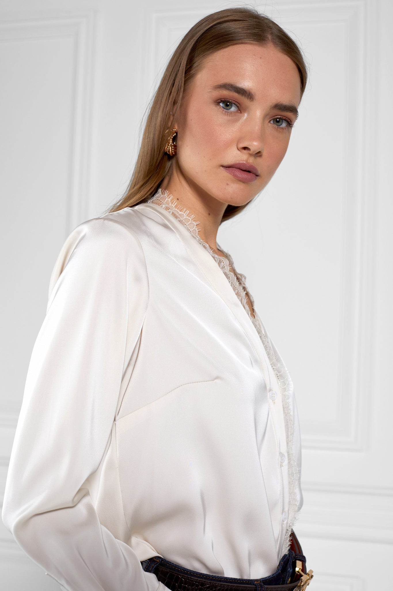 side of womens white long sleeve silk v neck blouse with white lace hem details