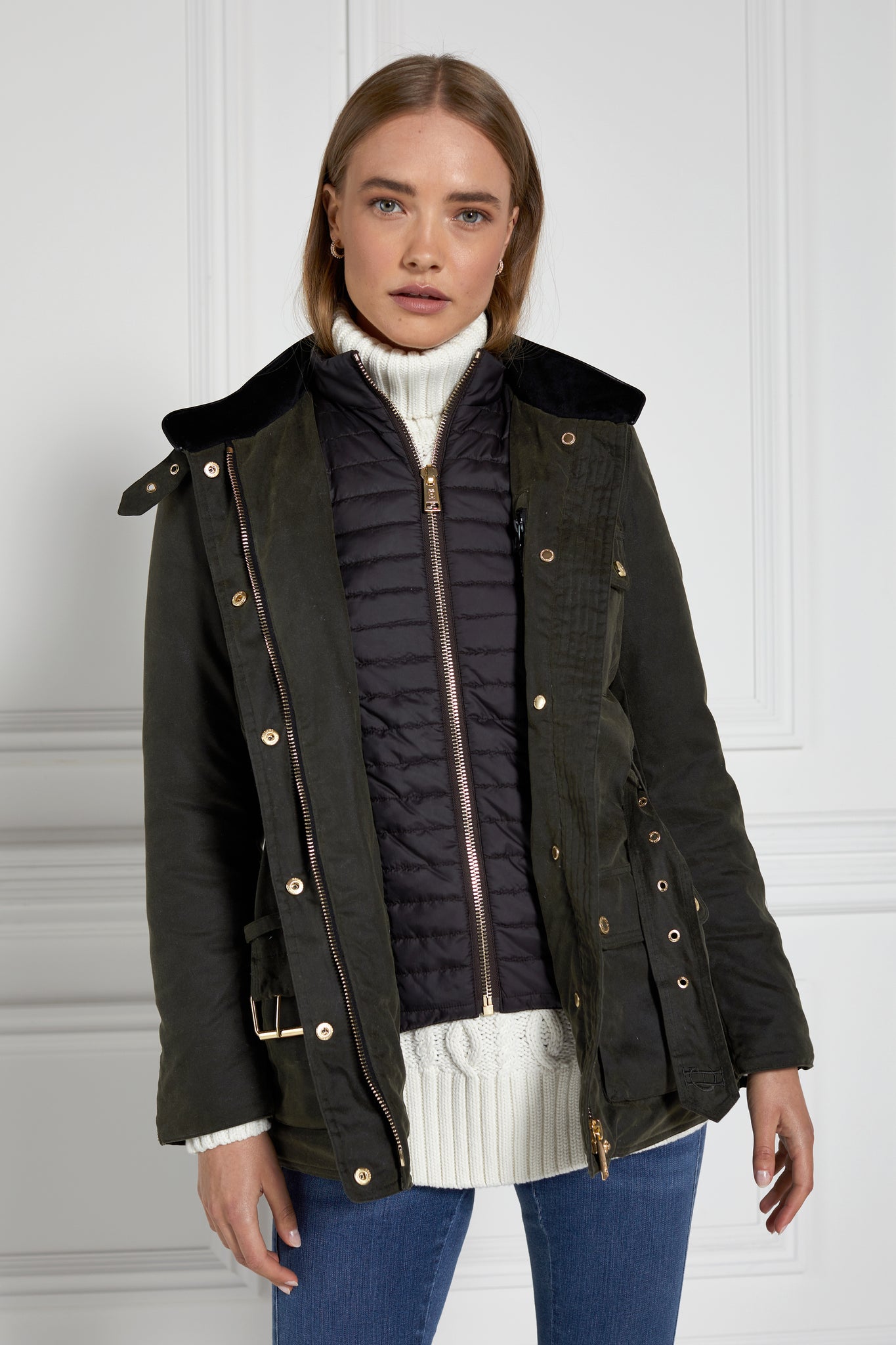 womens coated wax jacket in dark olive green with four patch pockets belted waist and internal black gilet 
