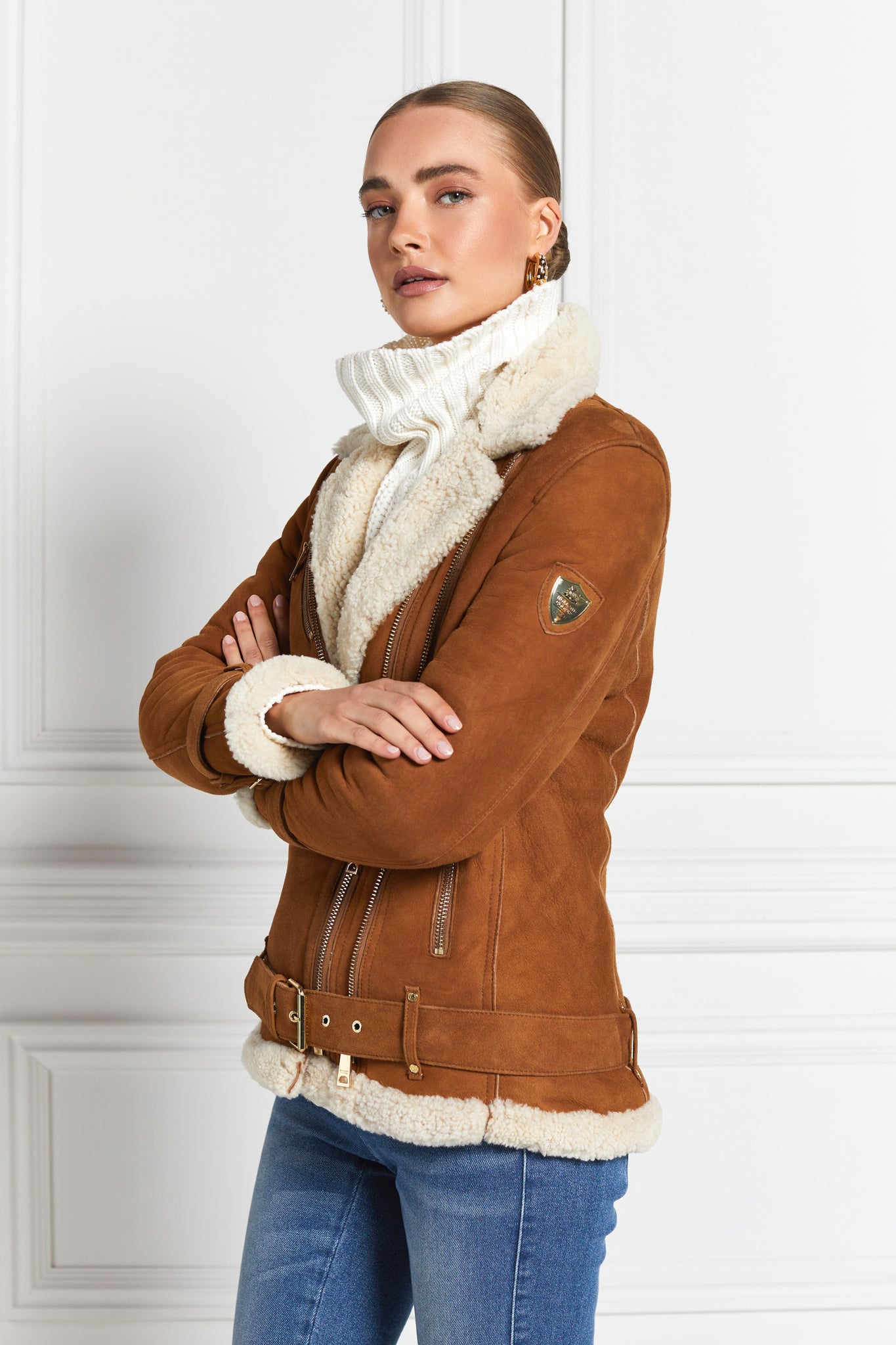 classic aviator jacket in tan leather with cream shearling inside that accents the cuffs hem and collar with belt detail on the hem and cuffs three pockets and angular zip fastening