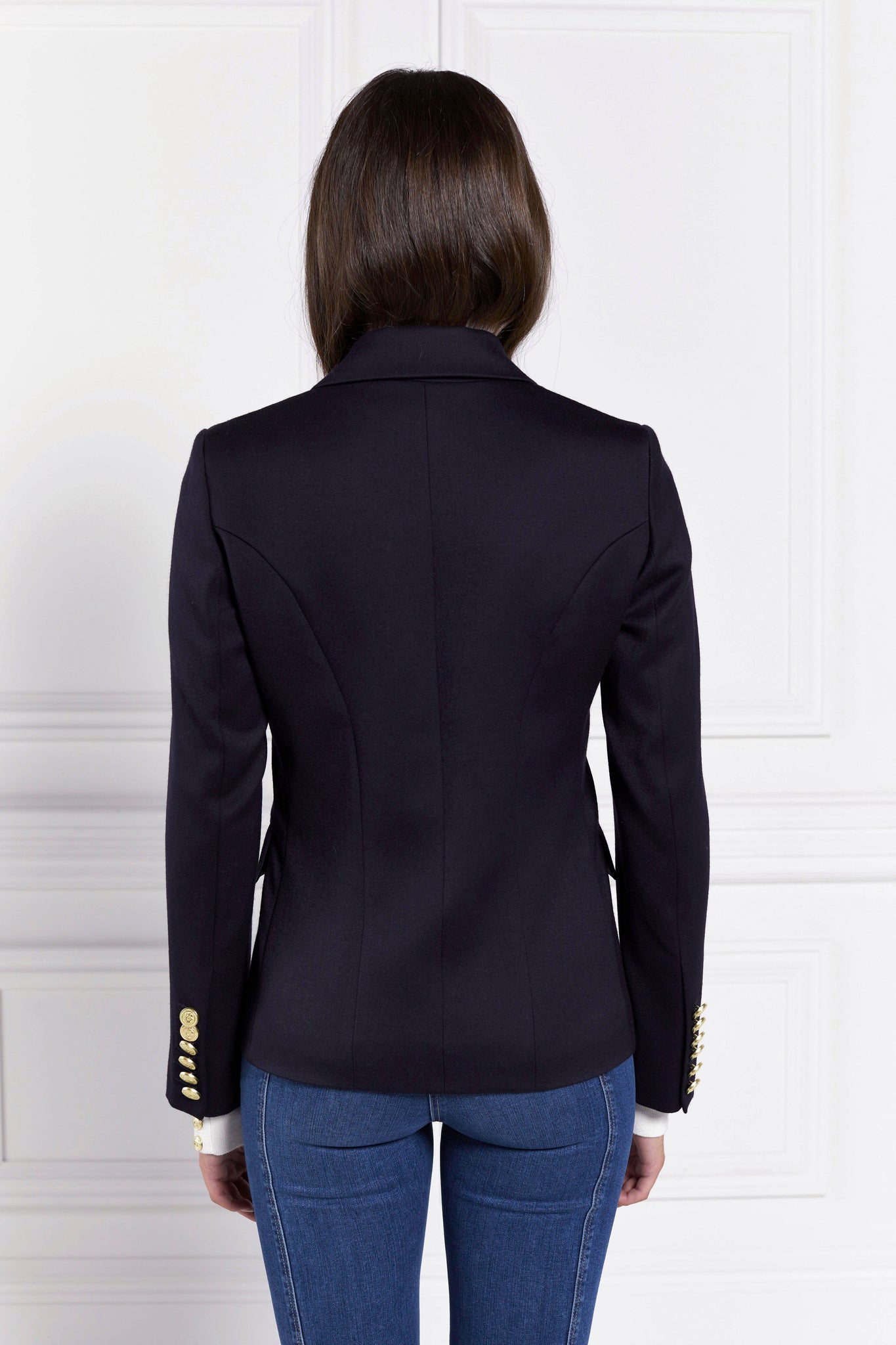 back of British made double breasted blazer that fastens with a single button hole to create a more form fitting silhouette with two pockets and gold button detailing this blazer is made from navy barathea fabric