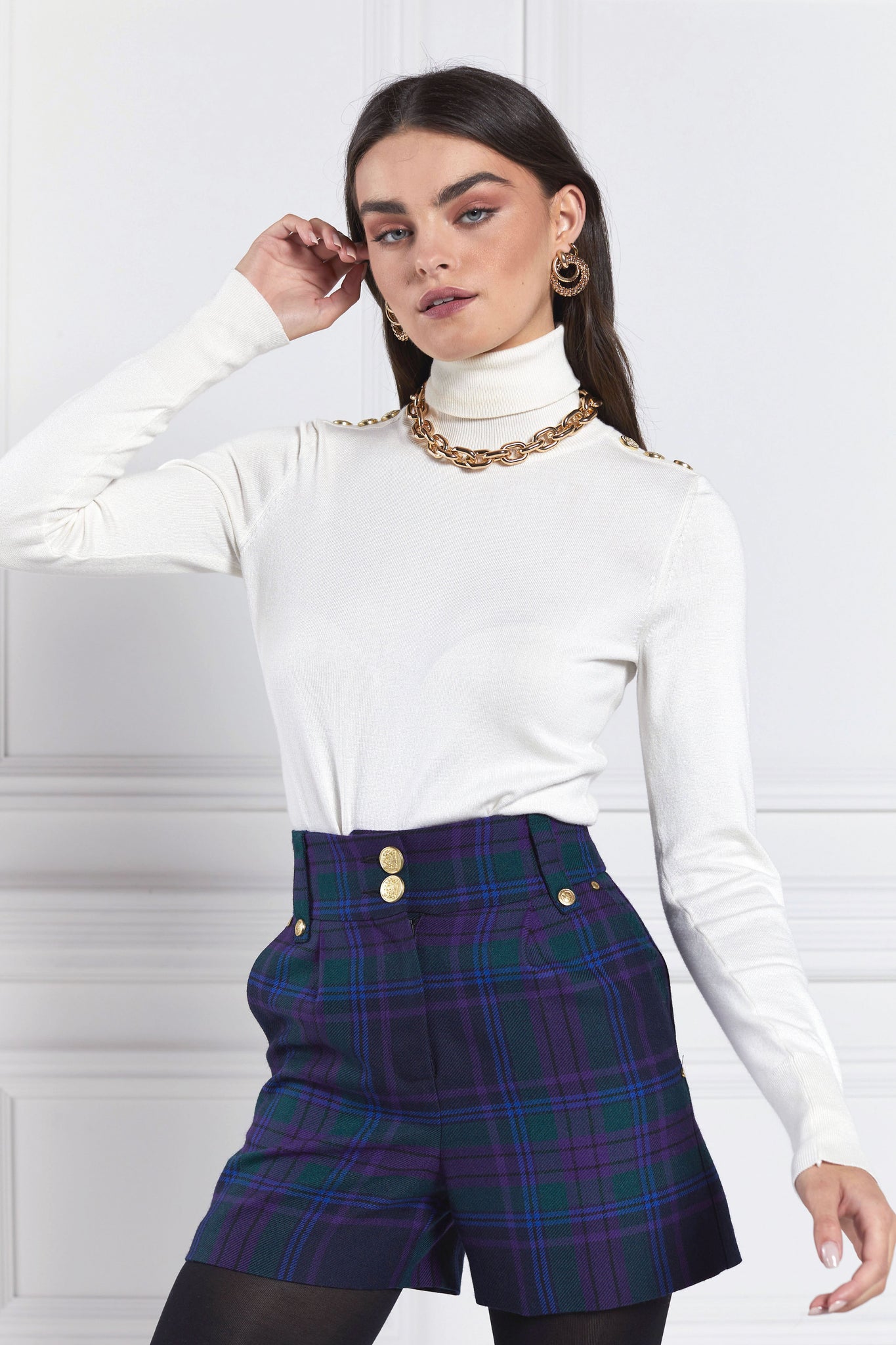 womens blue green and purple tartan high rise tailored shorts with two single knife pleats and centre front zip fly fastening with twin branded gold stud buttons and side hip pockets with branded rivet detailing at top and bottom of pockets worn with white roll neck