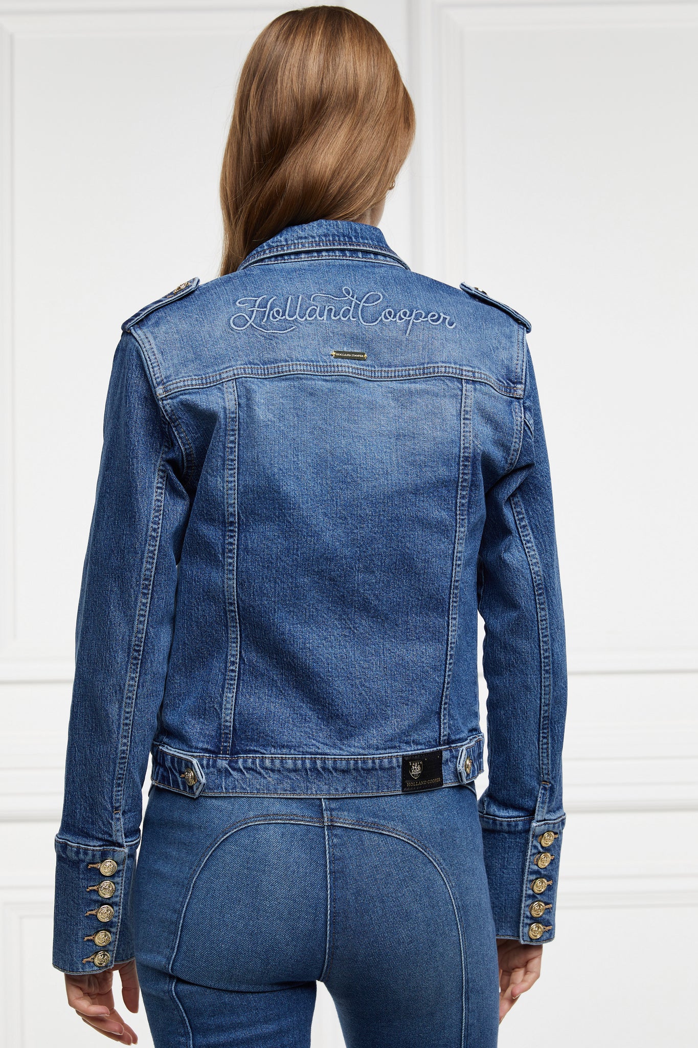 back of classic indigo denim jacket waist length with gold buttons on front, pockets and cuffs with holland cooper embroidery on back