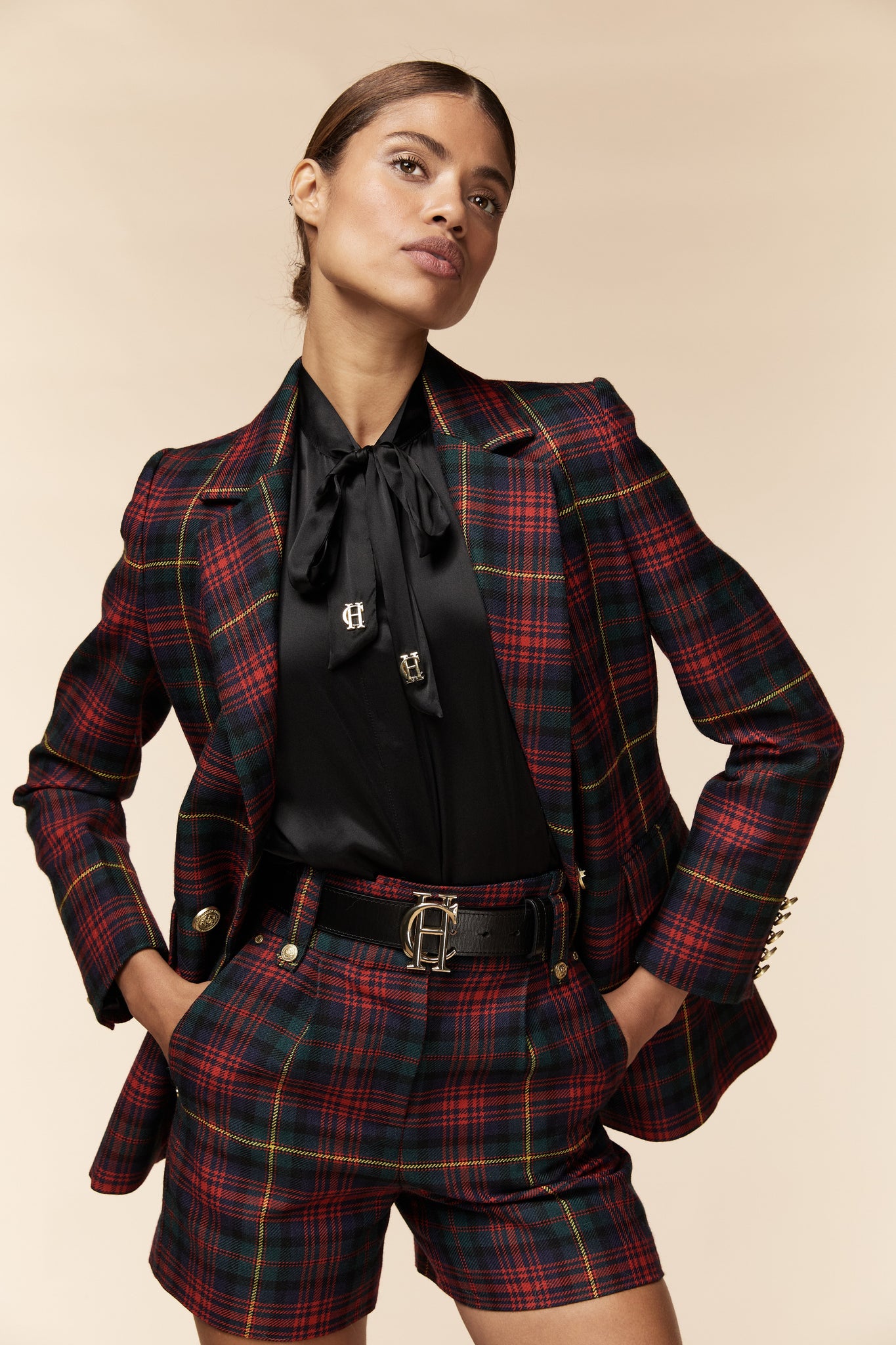 womens red green and blue tartan high rise tailored shorts with two single knife pleats and centre front zip fly fastening with twin branded gold stud buttons and side hip pockets with branded rivet detailing at top and bottom of pockets worn with matching double breasted blazer