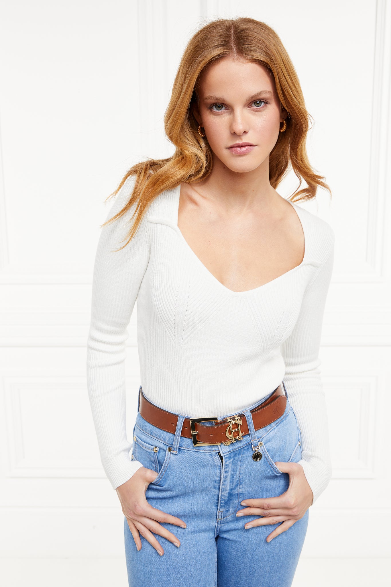 a form fitting finely ribbed long sleeved knitted top in cream with a sweetheart neckline and gold buttons on shoulders