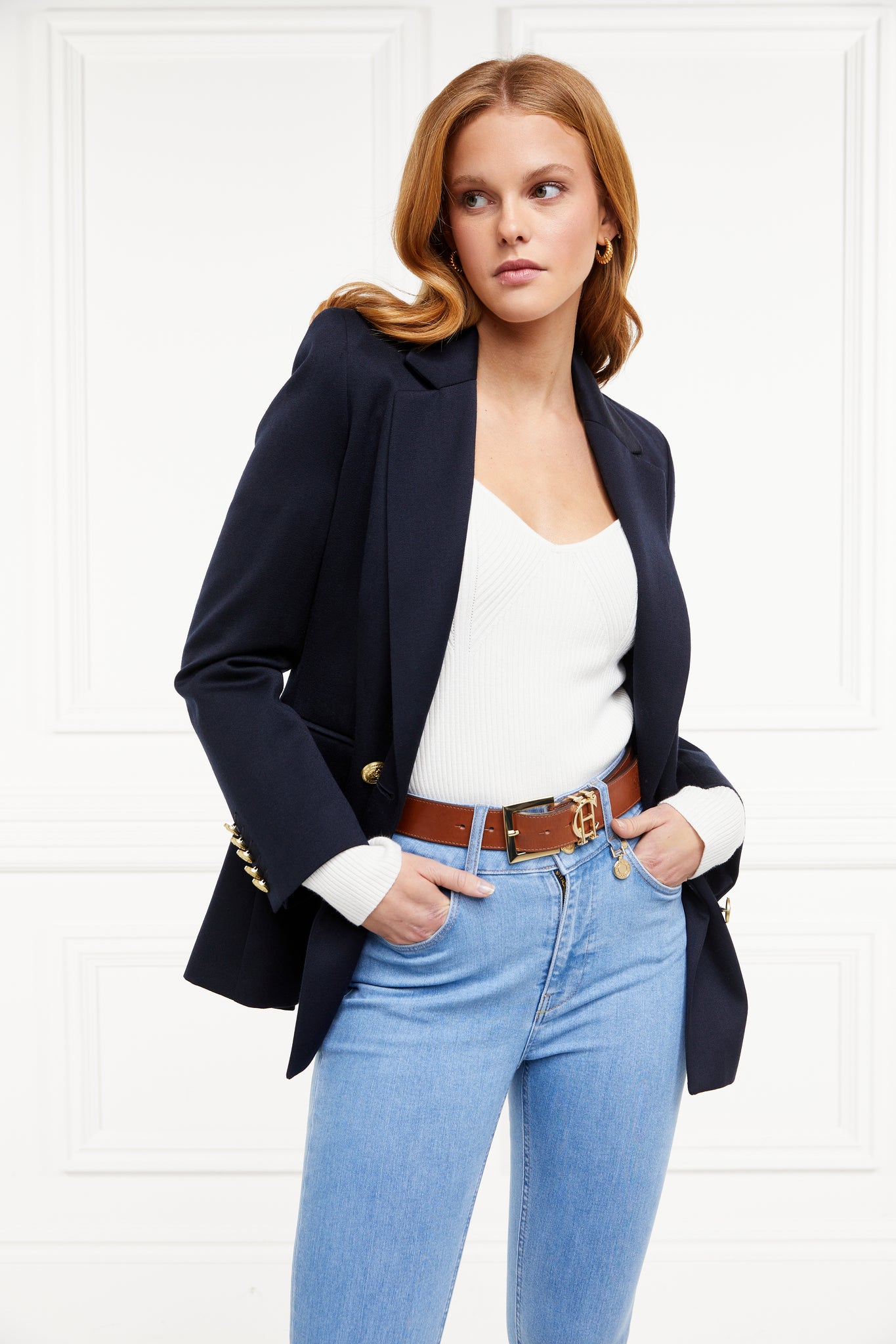 a form fitting finely ribbed long sleeved knitted top in cream with a sweetheart neckline worn under a navy double breasted blazer