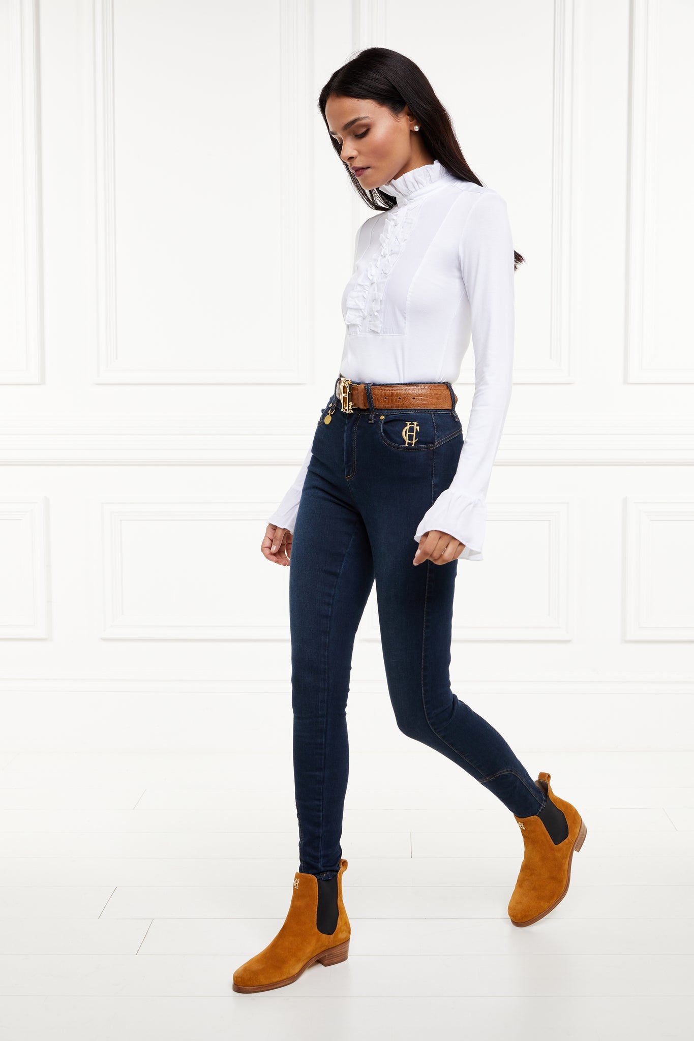 a neatly fitted white long sleeve top with ruffled neckline and cuffs with frilly chest detail