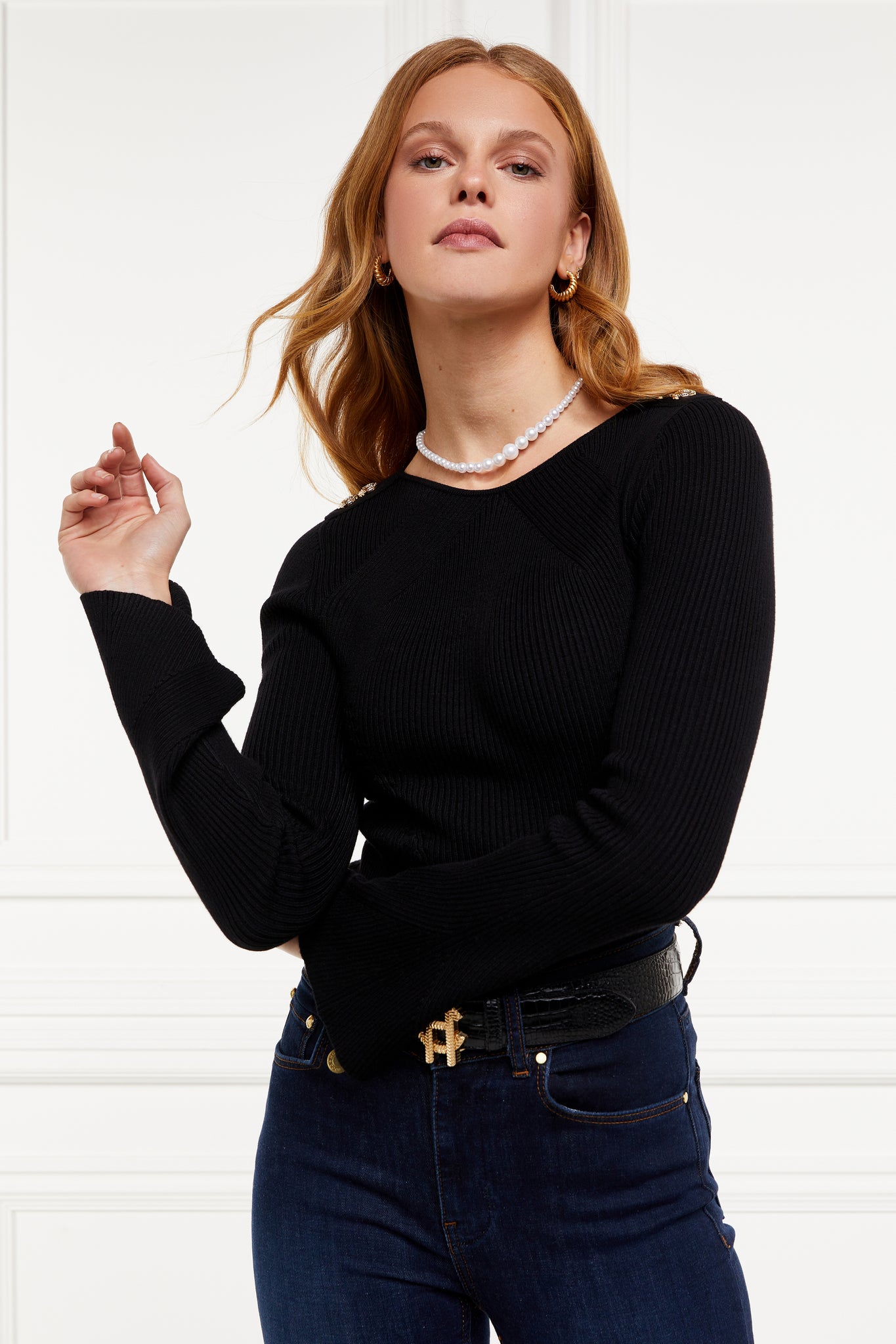a form fitting lightweight ribbed knit black jumper with a boat neckline and bell sleeves