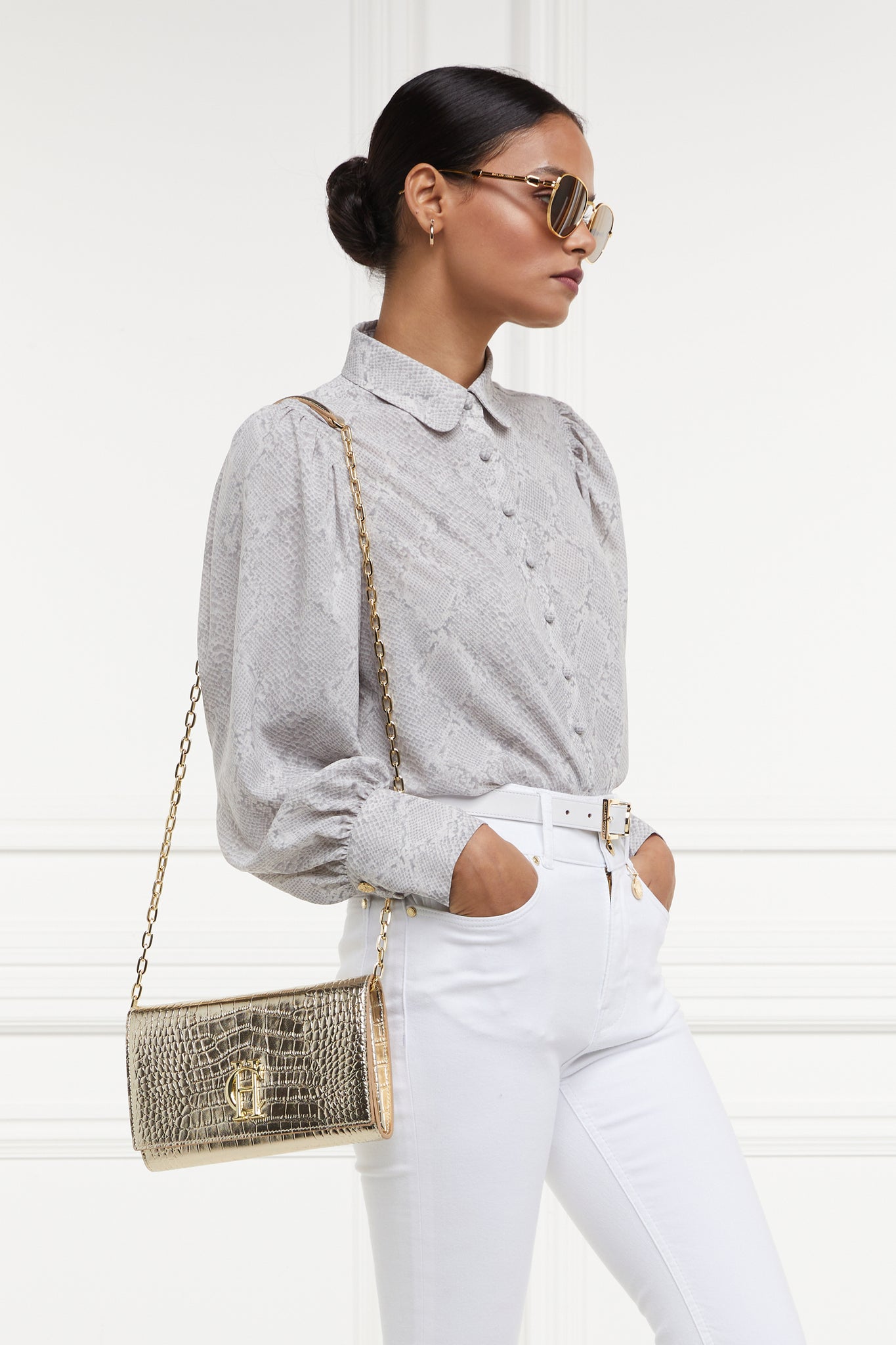 womens snake print shirt with white jeans and gold croc embossed leather bag with gold chain over shoulder
