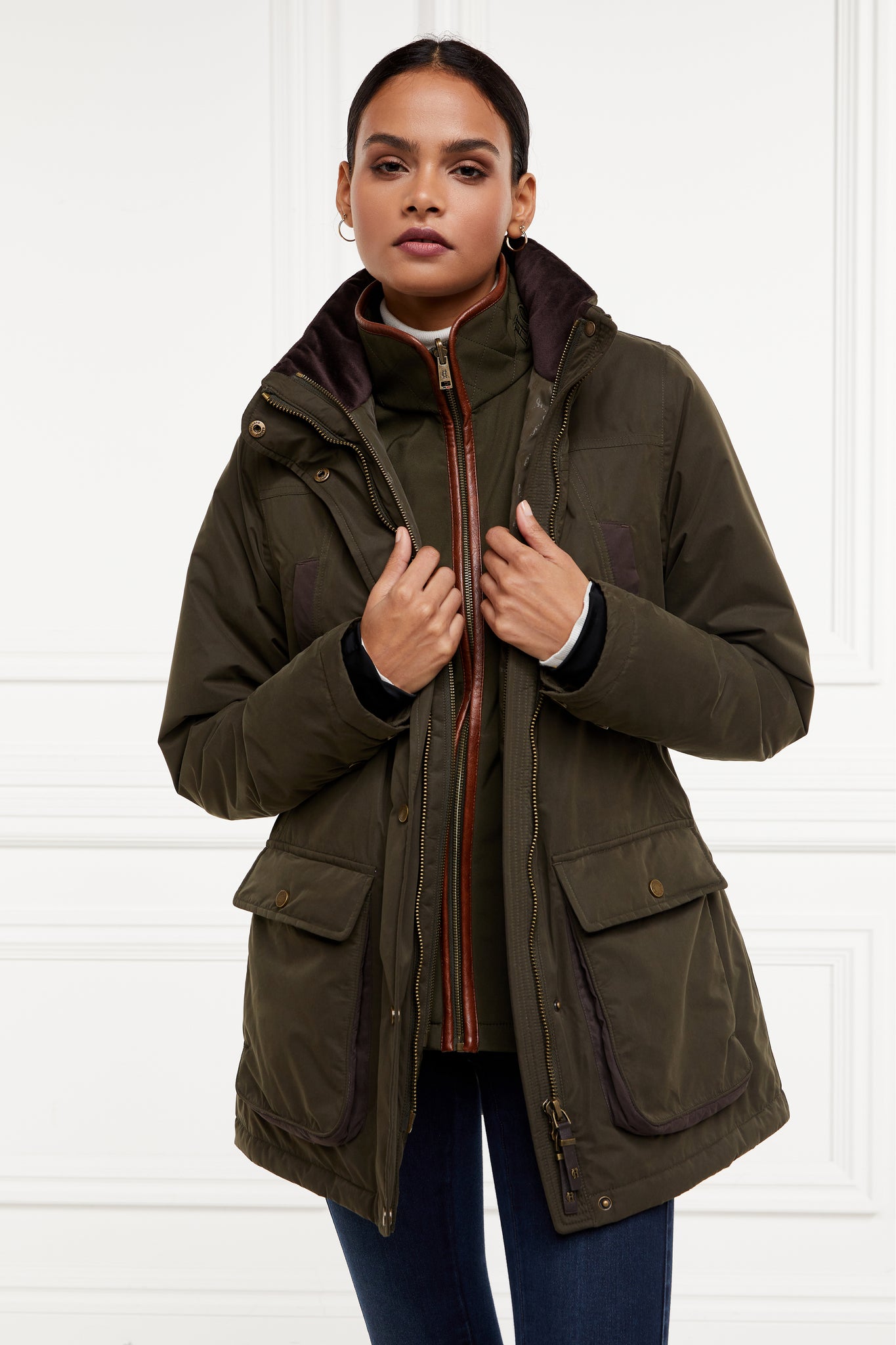 multiway coat in khaki that works as a 3 in 1 a waterproof outer coat with stowaway hood and deep pockets and black jersey storm cuffs and a fleece gilet inner with tan leather trims can be worn together or separately