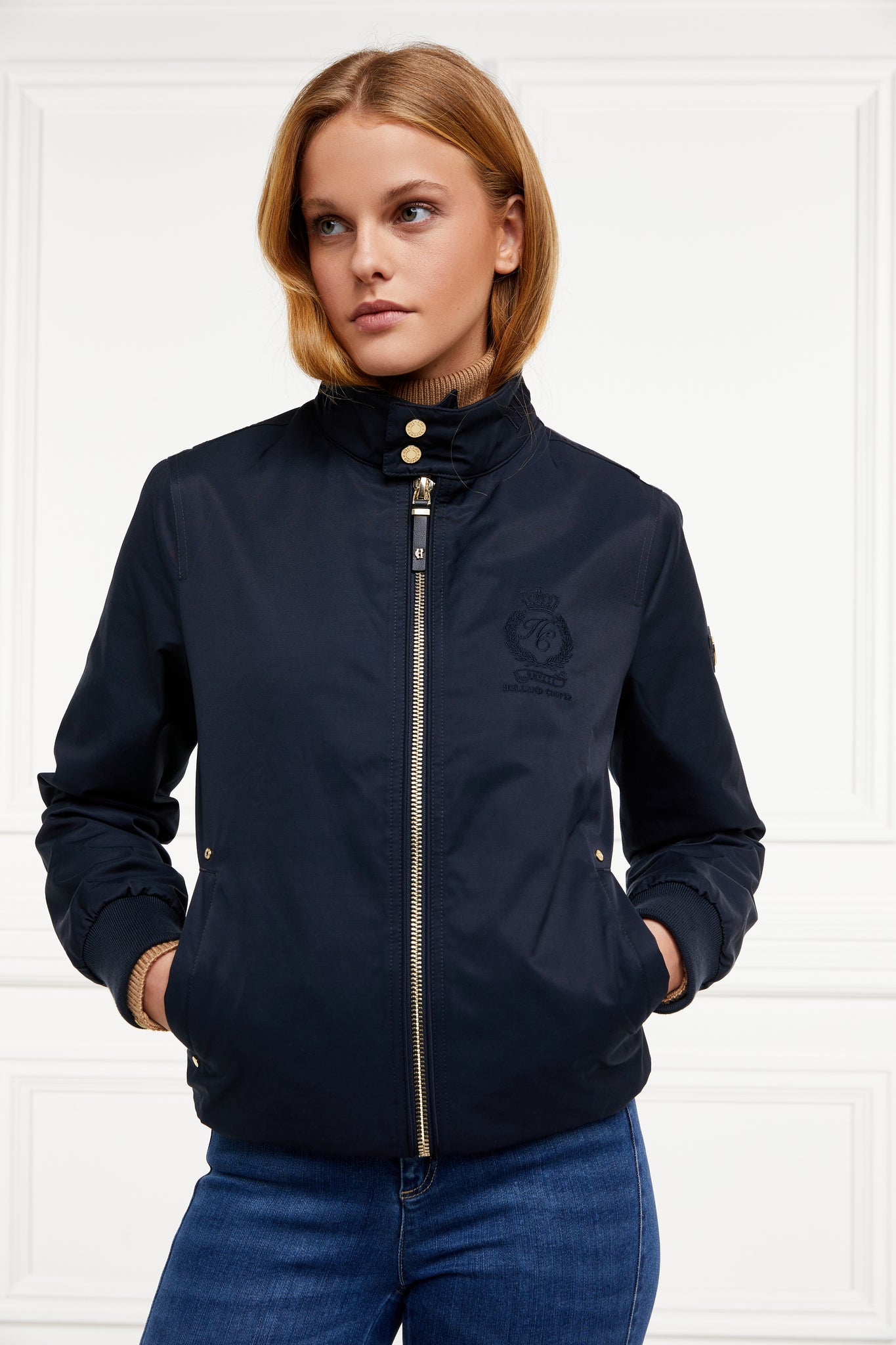 Womens navy 100% waterproof hoodless bomber style jacket with ribbed cuffs and hem, two pockets on hips a full zip down the centre front 