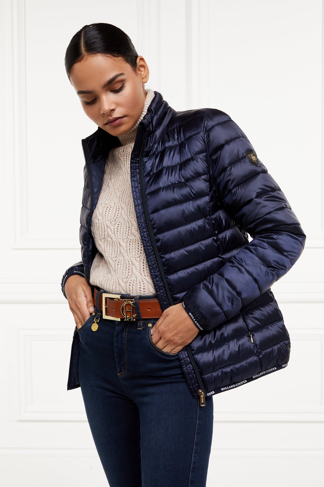 womens lightweight hoodless padded navy jacket with embroidery detail on back high neck and elasticated cuffs and hem. easily packs away into seperate small bag of the same colour with handle 